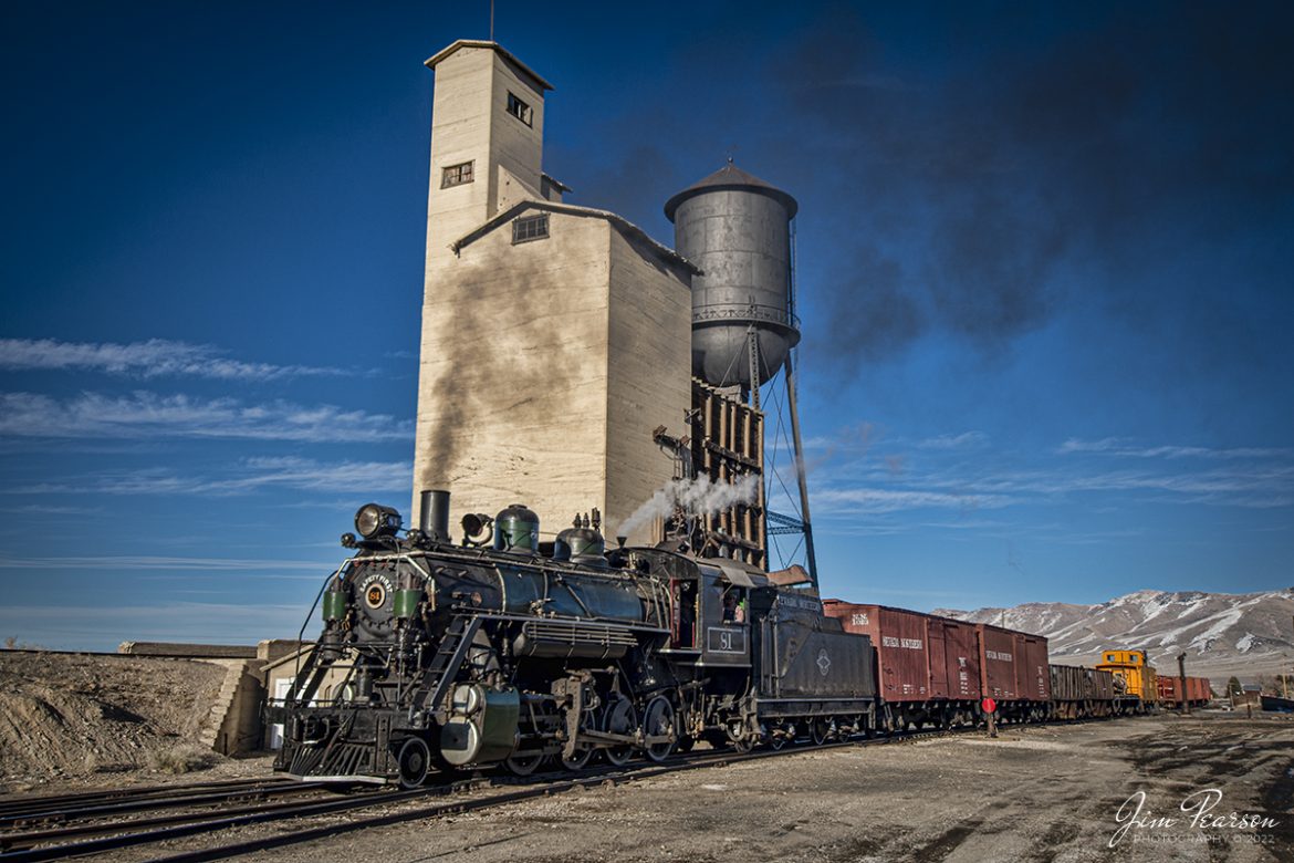 Nevada Northern Railway steam locomotive #81 pulls a short mixed freight past the coaling tower at Ely, Nevada during the museums Winter Photo Charter event on the morning of February 13th, 2022.

According to Wikipedia: The Nevada Northern Railway Museum is a railroad museum and heritage railroad located in Ely, Nevada and operated by a historic foundation dedicated to the preservation of the Nevada Northern Railway.

The museum is situated at the East Ely Yards, which are part of the Nevada Northern Railway. The site is listed on the United States National Register of Historic Places as the Nevada Northern Railway East Ely Yards and Shops and is also known as the "Nevada Northern Railway Complex". The rail yards were designated a National Historic Landmark District on September 27, 2006. The site was cited as one of the best-preserved early 20th-century railroad yards in the nation, and a key component in the growth of the region's copper mining industry. Developed in the first decade of the 20th century, it served passengers and freight until 1983, when the Kennecott Copper Company, its then-owner, donated the yard to a local non-profit for preservation. The property came complete with all the company records of the Nevada Northern from its inception.

Engine #81 is a "Consolidation" type (2-8-0) steam locomotive that was built for the Nevada Northern in 1917 by the Baldwin Locomotive Works in Philadelphia, PA, at a cost of $23,700. It was built for Mixed service to haul both freight and passenger trains on the Nevada Northern railway.

Tech Info: Nikon D800, RAW, Nikon 10-24 @ 24mm, f/5, 1/800, ISO 160.

#trainphotography #railroadphotography #trains #railways #jimpearsonphotography #trainphotographer #railroadphotographer #steamtrains #nevadanorthernrailway
