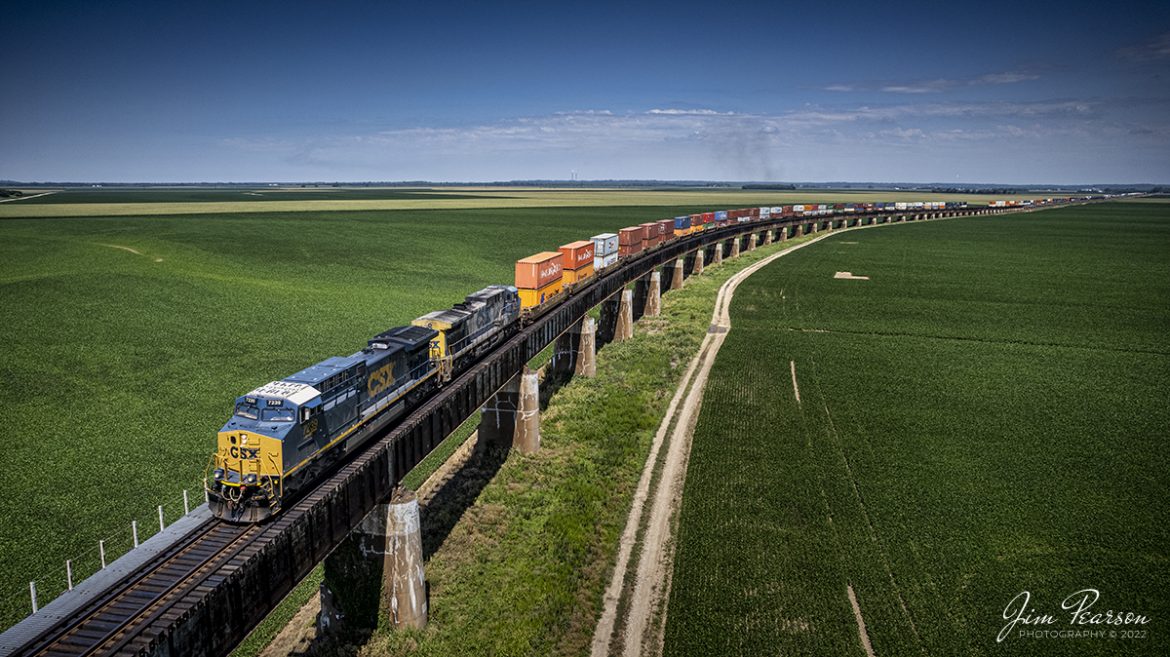 CSX hot intermodal I025 climbs the viaduct out of Evansville, Indiana on the Henderson Subdivision on a beautiful summer morning as it heads south on July 14th, 2022. The viaduct rises up over the Ohio River flood plane out of Evansville where the trackage crosses over the river into Kentucky at Henderson. During a heavy rainy season, the river can swell to where all the farm fields visible here often get covered by floodwaters.

Tech Info: DJI Mavic Air 2S Drone, RAW, 22mm, f/2.8, 1/1600, ISO 100.

#trainphotography #railroadphotography #trains #railways #dronephotography #trainphotographer #railroadphotographer #jimpearsonphotography