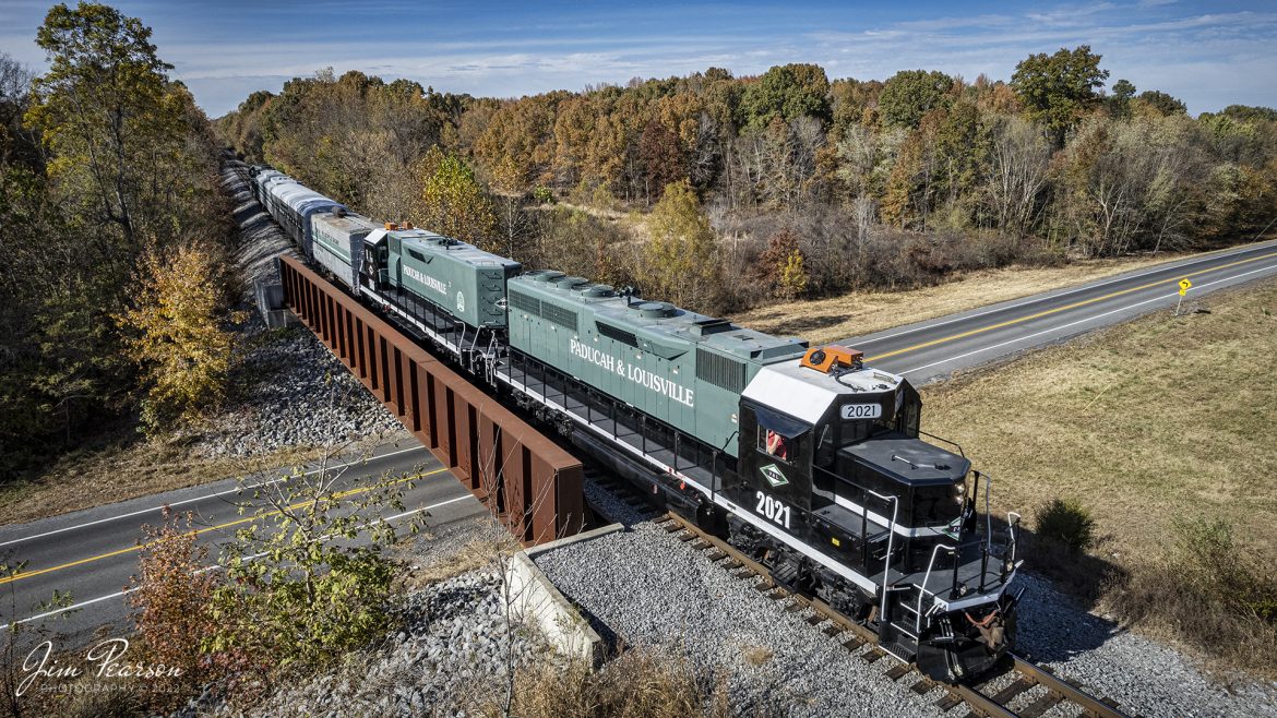 Saturday, October 29th, 2022, the Paducah and Louisville Railway (PAL) ran their Office Car Special (OCS) between Calvert City, Kentucky to just north of Barkley Dam to the railroad location known as Eureka, about 10 miles round trip. This event was in conjunction with their company picnic at Calvert City and the passengers were employees and their families. Here we catch them as they cross Ky 282 at Gilbertsville, Kentucky.

The consist was led by their 35th anniversary units PAL 2021 and 1986, followed by PAL 10, a generator car, built from an ex-L&N Milk Car that was manufactured in January 1958. Next was PAL II - lounge car or diner car from what I can find online, then PAL 1 "Bluegrass State I" business or lounge car, (ex-ICG 2, exx-IC 6, exxx-16). If anyone has more information on these cars, Id apricate your comments. The trailing engine is PAL 2127, Salute to our Troops locomotive, which led the train heading southbound to Calvert City, KY. 

Tech Info: DJI Mavic Air 2S Drone, 22mm, f/2.8, 1/2000, ISO 140.

#trainphotography #railroadphotography #trains #railways #dronephotography #trainphotographer #railroadphotographer #jimpearsonphotography #paducahandlouisvillerailway #pal #kentuckytrains