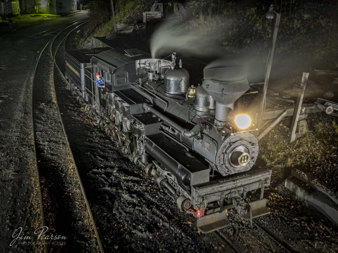 Cass Scenic Railway Shay locomotive number 11, (C-90-3) sits outside the engine house during the Rail Heritage Photography Weekend night photo shoot at Cass, West Virginia on November 5th, 2022. 

According to Wikipedia: Cass Scenic Railroad, is an 11-mile (18 km) long heritage railway owned by the West Virginia State Rail Authority and operated by the Durbin and Greenbrier Valley Railroad. The park also includes the former company town of Cass and a portion of the summit of Bald Knob, the highest point on Back Allegheny Mountain.

Founded in 1901 by the West Virginia Pulp and Paper Company (now WestRock), Cass was built as a company town to serve the needs of the men who worked in the nearby mountains cutting spruce and hemlock for the West Virginia Spruce Lumber Company, a subsidiary of WVP&P. At one time, the sawmill at Cass was the largest double-band sawmill in the world. It processed an estimated 1.25 billion board feet (104,000,000 cu ft; 2,950,000 m3) of lumber during its lifetime. In 1901 work started on the 4 ft 8+1⁄2 in (1,435 mm) standard gauge railroad, which climbs Back Allegheny Mountain. 

The railroad eventually reached a meadow area, now known as Whittaker Station, where a logging camp was established for the immigrants who were building the railroad. The railroad soon reached the top of Gobblers Knob, and then a location on top of the mountain known as 'Spruce'. The railroad built a small town at that location, complete with a company store, houses, a hotel, and a doctor's office. Work soon commenced on logging the red spruce trees, which grew in the higher elevations.

Tech Info: DJI Mavic Air 2S Drone, 22mm, f/2.8, 3sec exposure, +0.3 stops, ISO 200.

#trainphotography #railroadphotography #trains #railways #dronephotography #trainphotographer #railroadphotographer #jimpearsonphotography #cassscenicrailway #trainsfromtheair #steamtrains