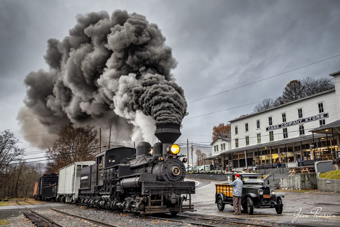Mower Lumber Company steam locomotive, Shay No. 2, through the main crossing in downtown Cass, West Virginia as they pass a gentleman and is old truck under rainy skies, on November 6th, 2022, during the Mountain Rail WV, Rail Heritage Photography Weekend at the Cass Scenic Railroad, Cass, WV, from November 4-6th, 2022. 

According to the Cass website: Shay #2, a Pacific Coast Shay, was constructed in July of 1928 for the Mayo Lumber Company of Paldi, Vancouver Island, British Columbia. A Pacific Coast Shay is a souped-up model of the class C-70 3 truck Shay. The Pacific Coast features superheat, a firebox that is 13 inches longer, lower gear ratio, steel cab, cast steel trucks, and steel girder frame. A feature of the steel girder frame is the large opening for exposing staybolts.

Also, the cylinders were designed so they attached only to the locomotive frame, rather than to the boiler shell as in other Shays. This allowed for easier access and maintenance. #2 is the only Shay of its kind in the east. Shay #2, originally a wood burner, spent its working commercial life with four companies in British Columbia including Lake Logging Company, Cowichan Lake B.C. and Western Forest Industries, Honeymoon Bay, B.C. Later converted to burn oil then rebuilt to burn bituminous coal at Cass, #2 is the only known Shay to have used all three types of fuel. The locomotive ended its career switching cars on Vancouver docks in 1970, making it one of the last commercially used Shays.

Tech Info: Nikon D800, RAW, Nikon 10-24mm @ 20mm, f/2.8, 1/400, ISO 160.

#trainphotography #railroadphotography #trains #railways #trainphotographer #railroadphotographer #jimpearsonphotography #cassscenicrailway #steamtrains
