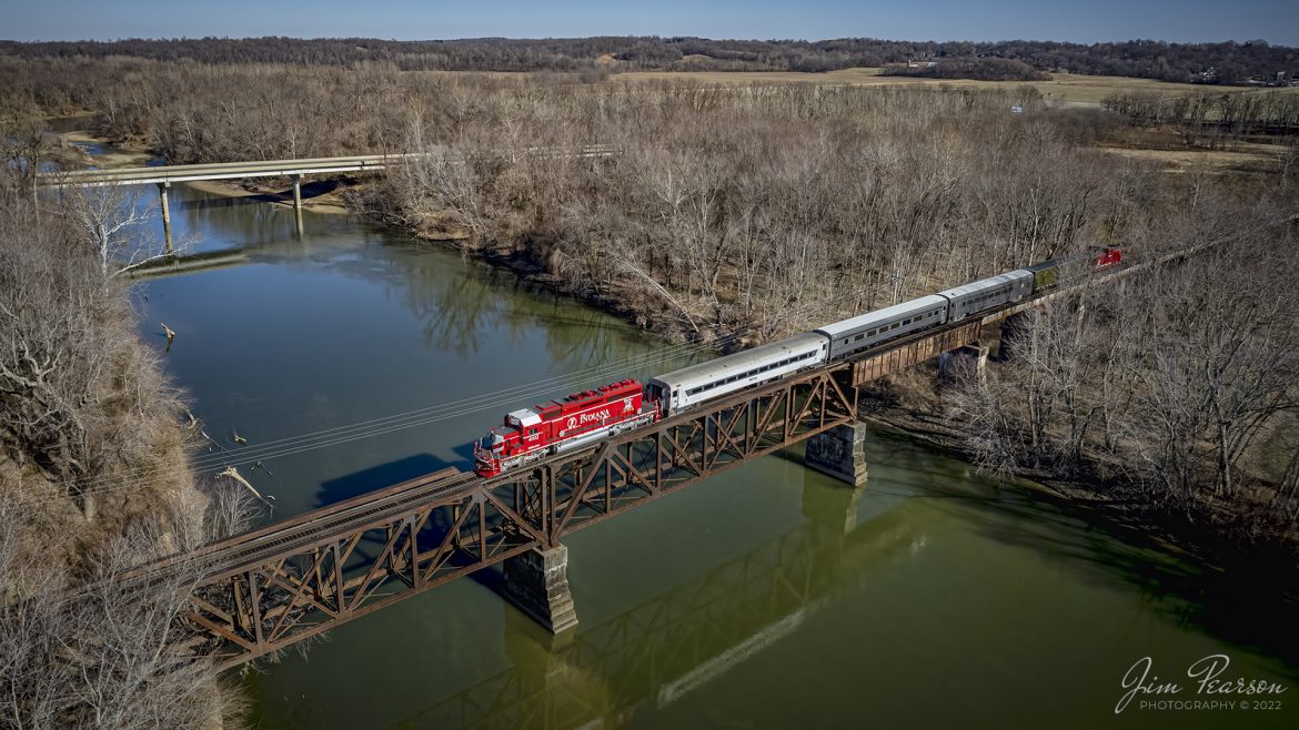 The Indiana Railroad (INRD), "Honoring First Responders" locomotive 4002, leads the railroads Santa Train on December 3rd, 2022, as they pass over the White River at Elliston, Indiana. The Saturday run of the train made stops between Bloomington and Jasonville, IN to allow the kids in various towns along the way to come on board and have a brief visit with Santa Claus. At this location they just left Bloomfield and are heading for their next stop at Linton, IN.

The Indiana Railroad (reporting mark INRD) is a United States Class II railroad, originally operating over former Illinois Central Railroad trackage from Newton, Illinois, to Indianapolis, Indiana, a distance of 155 miles (249 km). This line, now known as the Indiana Rail Road's Indianapolis Subdivision, comprises most of the former IC/ICG line from Indianapolis to Effingham, Illinois; Illinois Central successor Canadian National Railway retains the portion from Newton to Effingham. 

INRD also owns a former Milwaukee Road line from Terre Haute, Indiana, to Burns City, Indiana (site of the Crane Naval Surface Warfare Center), with trackage rights extending to Chicago, Illinois. INRD no longer serves Louisville, Kentucky, and the Port of Indiana on the Ohio River at Jeffersonville, Indiana, through a haulage agreement with the Louisville & Indiana Railroad (LIRC).

Tech Info: DJI Mavic Air 2S Drone, RAW, 22mm, f/2.8, 1/2000, ISO 140.

#trainphotography #railroadphotography #trains #railways #dronephotography #trainphotographer #railroadphotographer #jimpearsonphotography #inrd #IndianaRailroad #RegionalRailroad #trainsfromtheair