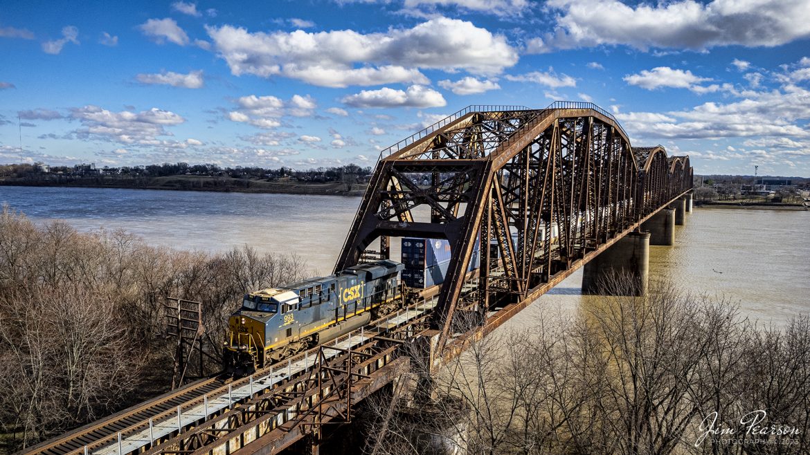 CSXT 993 leads hot intermodal I028 across the Ohio River from Henderson, Kentucky as it heads north on the CSX Henderson Subdivision at Rahm, Indiana on January 4th, 2022. From here it heads down the long viaduct over the flood plain into Evansville, IN as it makes its run from Duval Yard at Jacksonville, FL to Bedford Park, IL (Chicago).

The CSX Henderson Subdivision is part of the Nashville Division, and it runs between Nashville, Tennessee, and Evansville Indiana for a length of about 145.3 miles of mainline track. On average it sees around 20-30 trains a day, with four of them being hot intermodals.

Tech Info: DJI Mavic Air 2S Drone, RAW, 22mm, f/2.8, 1/2500, ISO 120.

#trainphotography #railroadphotography #trains #railways #dronephotography #trainphotographer #railroadphotographer #jimpearsonphotography #csxhendersonsubdivision #csx #trainsfromtheair