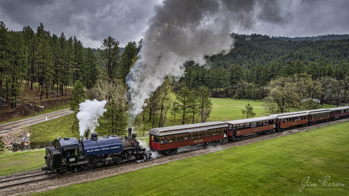 The 1880 Train, Black Hills Central Railroad locomotive 108 heads through the countryside as it pulls its train from Keystone to Hill City, SD on May 30th, 2022 under stormy skies.

According to their website: Locomotive #108 joined its nearly identical twin, #110, at the beginning of the 2020 season following a four-year restoration. It is a 2-6-6-2T articulated tank engine that was built by the Baldwin Locomotives Works in 1926 for the Potlatch Lumber Company. It later made its way to Weyerhaeuser Timber Company and eventually to the Northwest Railway Museum in Snoqualmie, Washington.

The acquisition and subsequent restoration of locomotive #108 completed a more than 20-year goal of increasing passenger capacity which began with the restoration of #110 and the restoration of multiple passenger cars. Both large Mallet locomotives (pronounced Malley) can pull a full train of seven authentically restored passenger cars, up from the four cars utilized prior to their addition to the roster.

Tech Info: Nikon D800, RAW, Sigma 24-70mm @ 24mm, f/4.5, 1/800, ISO 100.

#trainphotography #railroadphotography #trains #railways #jimpearsonphotography #trainphotographer #railroadphotographer #blackhillscentralrailroad #STEAM #steamtrains