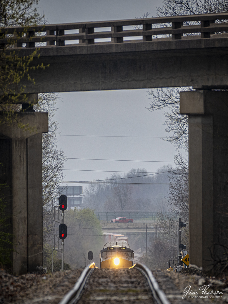 The nose of CSXT 3154 peeks over the rise as CSX I025 passes through the Hospital Drive crossing, approaching the Main Street overpass at Madisonville, Ky, on March 24th, 2023, on the Henderson Subdivision. This image was made as the train was about one half mile away from where I was standing, with a 440mm lens. The compression from the lens makes the train look much closer than what it was.

Tech Info: Nikon D800, RAW, Sigma 150-600mm @ 440mm, f/6, 1/1000, ISO 800.

#trainphotography #railroadphotography #trains #railways #jimpearsonphotography #trainphotographer #railroadphotographer