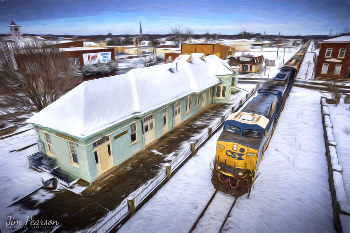 CSXT 739 leads loaded grain train G419 southbound past the old Louisville and Nashville (L&N) Railroad Depot after our first snowfall of the year on the Henderson Subdivision on January 7th, 2022. The snow which began to fall on the 6th brought a total of 4-6 inches of snow to the region and caused delays on the railroad due to switch problems along the line due to the snow and cold.

According to Wikipedia: “The L &N Railroad Depot in the Hopkinsville Commercial Historic District of Hopkinsville, Kentucky is a historic railroad station on the National Register of Historic Places. It was built by the Louisville & Nashville Railroad in 1892.

The year 1832 saw the first of many attempts to woo a railroad to Hopkinsville. This first attempt was to connect Hopkinsville to Eddyville, Kentucky. In 1868 Hopkinsville finally obtained a railroad station, operated by the Evansville, Henderson, & Nashville Railroad. The Louisville & Nashville Railroad acquired the railroad in 1879.

The Hopkinsville depot is a single-story frame building with a slate roof. It has six rooms: A Ladies Waiting room (the room closest to the street), a General Waiting Room, a Colored Waiting Room, a baggage room (the furthest room from the street), a ticket office (the only room which connected to all three waiting rooms), and a ladies’ restroom. Immediately outsides were warehouses for freight, usually tobacco.

Its last long-distance (passenger) train was the Louisville and Nashville’s Georgian, last operating in 1968.

During its operating years, the Hopkinsville depot was a popular layover spot for those traveling by train. It was the only Louisville & Nashville station between Evansville, Indiana and Nashville, Tennessee where it was legal to drink alcohol. Hopkinsville got the nickname “Hop town” due to train passengers asking the conductors when they would arrive at Hopkinsville, so they could “hop off and get a drink”.

The Hopkinsville L & N Railroad Depot was placed on the National Register of Historic Places on August 1, 1975. CSX, which bought out the Louisville & Nashville, still run trains on the tracks next to the depot, but do not stop.”

Tech Info: DJI Mavic Air 2S Drone, RAW, 22mm, f/2.8, 1/3200, ISO 110.

#trainphotography #railroadphotography #trains #railways #jimpearsonphotography #trainphotographer #railroadphotographer