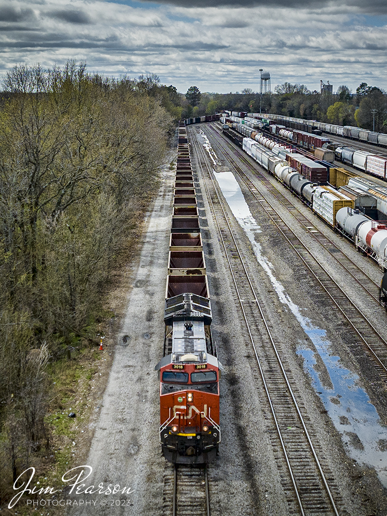 Canadian National 3018 leads a empty coal train as it waits in the yard at Fulton, Ky waits for a crew, CN Fulton Subdivision, on March 25th, 2023. 

Im told that on average 10-15 trains a day pass through Fulton, Ky where the CN Cairo, CN Fulton Subdivisions and the West Tennessee Railroad all come together. Also, Amtrak has a depot here and is a flag stop for the City of New Orleans.

The first railroad deed was sold in 1857, and construction reached Pontotoc in 1859. At that time Fulton was referred to as the end of the line by the United States Government and all mail was addressed to this extent. In 1896, the Illinois Central Railroad owned the two railroad lines that crossed Fulton, which saw 30 passenger trains a day and 3,000 freight cars that picked up or delivered cargo. The freight cars would usually have bananas that would stop in Fulton to be re-iced and then shipped to the rest of the country. Through this process, Fulton became known as the Banana Capital of the World.

Tech Info: DJI Mavic 3 Classic Drone, RAW, 24mm, f/2.8, 1/3200, ISO 230.

#trainphotography #railroadphotography #trains #railways #dronephotography #trainphotographer #railroadphotographer #jimpearsonphotography #kentuckytrains #CN #CNrailway #FultonKy #mavic3classic #drones #trainsfromtheair #trainsfromadrone
