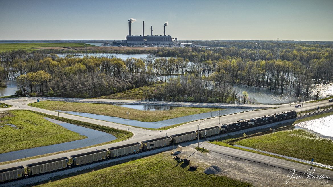 Norfolk Southern 8092, 3619 and 3613 lead a loaded coal train as they pull onto the lead, headed for the Duke Energy power Gibson plant, just outside of East Mount Carmel, Indiana on April 8th, 2023.

According to Wikipedia: The Gibson Generating Station was originally built as a two-unit coal-fired power plant in 1972 by Public Service Indiana (PSI) with initial plans to build 8 units. The 1970s saw the addition of Units 3, 4. However, environmental regulations prevented the construction of the two remaining additional units in the original plan. In 1982, Unit 5 was constructed, and two more stacks were added. In the 1990s, number 4 was separated from number 3's stack, and each was given its own stack, while Units 1 and 2 continued to share a stack.

Cinergy took over PSI in 1995. After the merger, all five units were fitted with new Selective catalytic reduction (SCR) equipment, mounted on the back of each unit. During this construction, one of the largest cranes in the world was erected at Gibson Station. Despite this, the station only had 4 stacks for 5 units. Units 1 & 2 still shared a single flue stack and Unit 3 was still using the old 3 & 4 stack. (Both stacks have since been removed bringing the number of visible stacks back down to four).

Duke Energy took over Cinergy in May 2006.

Tech Info: DJI Mavic 3 Classic Drone, RAW, 24mm, f/2.8, 5000, ISO 230.

#trainphotography #railroadphotography #trains #railways #dronephotography #trainphotographer #railroadphotographer #jimpearsonphotography #kentuckytrains #csx #csxrailway #MadisonvilleKy #mavic3classic #drones #trainsfromtheair #trainsfromadrone #norfolksouthernrailway, #coaltrain #dukeenergyplant