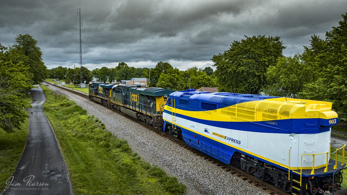 CSX M648 heads north under stormy skies with West Coast Express 903, a F59PHI engine as their 3rd unit dead in tow, at Mortons Gap, Kentucky on the Henderson Subdivision on May 12th, 2023. From the looks of the engine, it is fresh out of the shops somewhere down south and is on its way back north to Canada.

According to CPTDB Wiki, it is one of several GMDD F59PHI locomotives owned by TransLink for use on the West Coast Express in Canada. During the procurement process for these locomotives in 1994, three locomotive manufacturers entered the bid to supply six locomotives: General Motors, MK Rail, and AMF Technotransport Inc. GM was initially eliminated as it was the most expensive option and MK Rail was to be the manufacturer, as recommended by transit staff. The contract was valued at $11.2 million and would've been six rebuilt engines costing $1.86 million each. However, BC Transit overruled the staff decision and went with General Motors, despite being the most expensive option. The contract given to GM was revised to five locomotives instead of six, valued at $16.5 million.

According to masstransit.com 903 is one of Seven locomotives on the West Coast Express that will be refurbished under a project to be paid for by the governments of Canada, British Columbia and TransLink. The Metro Vancouver commuter rail service has been in service since 1995 and sees more than 2.6 million boardings annually.

The project includes refurbishing the engines of six of the seven locomotives to extend their lifespan by 15 years. In addition, all head end power units, which provide heat and lighting to the passenger cars, will be replaced to reduce emissions, improve energy efficiency, and allow operation of longer trains.

The locomotives will be refurbished one at a time to ensure there is no disruption in service. Once work is complete, each locomotive will be tested, commissioned, and returned to service before work starts on the next locomotive.

Tech Info: DJI Mavic 3 Classic Drone, RAW, 24mm, f/2.8, 1/1000, ISO 190.

#trainphotography #railroadphotography #trains #railways #dronephotography #trainphotographer #railroadphotographer #jimpearsonphotography #PALtrains #mavic3classic #drones #trainsfromtheair #trainsfromadrone #kentuckytrains #WestCoastExpress