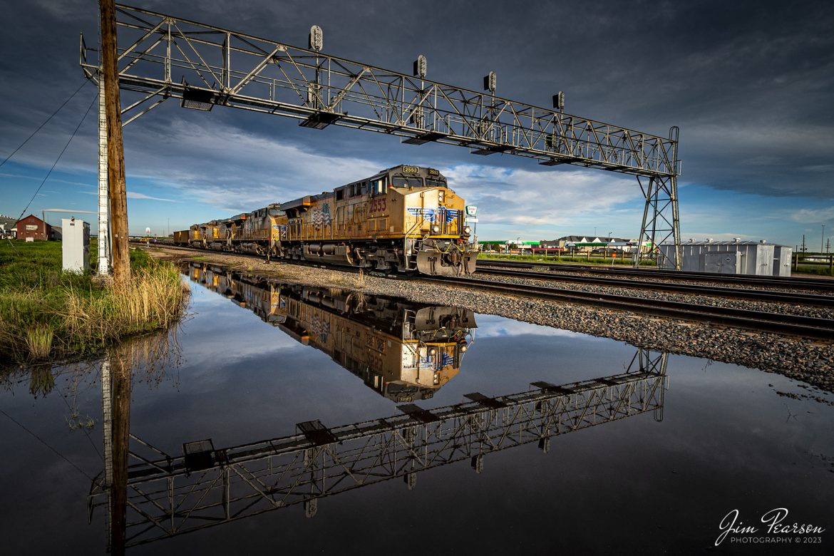 Union Pacific 2553 leads an eastbound mixed freight into the rising sun as it passes under the signal bridge, approaching the yard at Cheyanne, Wyoming, on the Laramie Subdivision on June 18th, 2023. Everything reflected in the water from an early morning rain adds a nice bit of drama to the image, however, the mosquitoes were terrible near it!

Tech Info: Nikon D800, RAW, Rokinon 11mm, f/5.6, 1/500, ISO 250.

#trainphotography #railroadphotography #trains #railways #dronephotography #trainphotographer #railroadphotographer #jimpearsonphotography #UPtrains #NikonD800 #UnionPacific #WyomingTrains