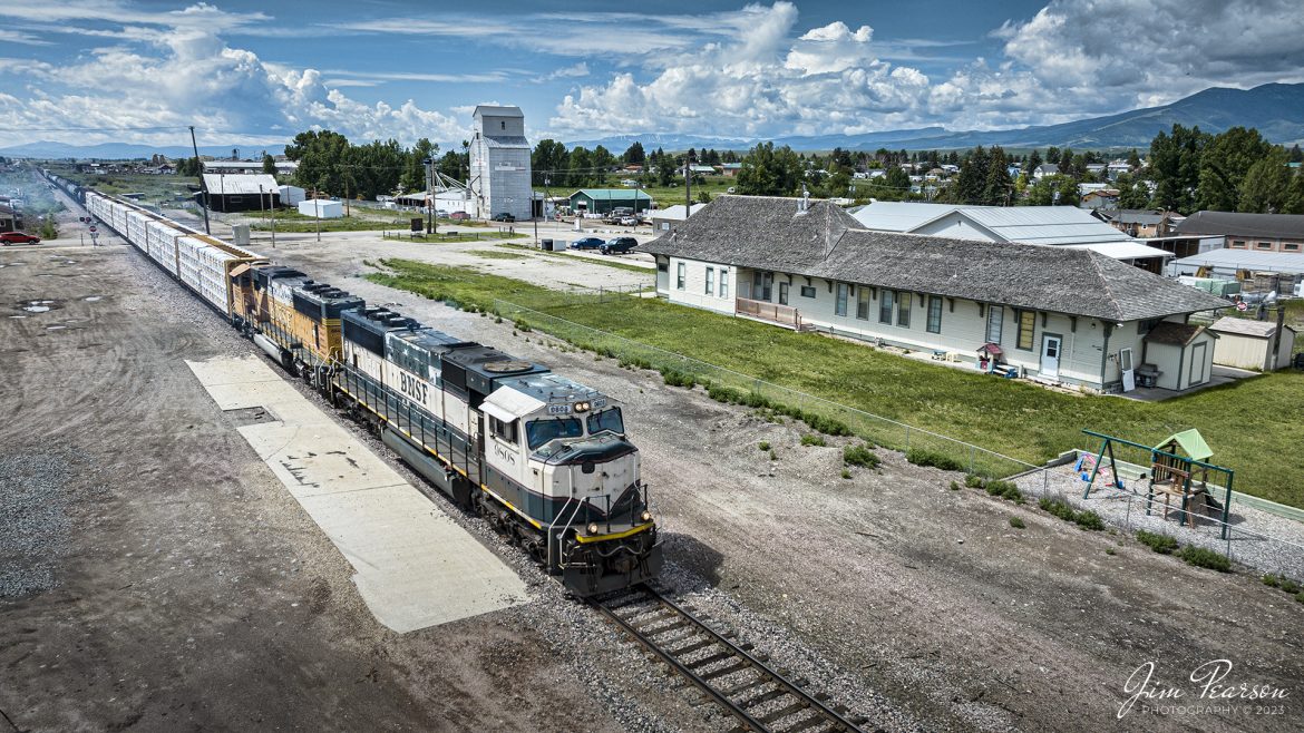 BNSF 9808 and 8843, lead a mixed freight past the Community Evangelical Free Church (Depot Church) at Deer Lodge, Montana, on June 26th, 2023, as it heads north after completing a pickup at one of the local industries in Deer Lodge. The depot used to belong to the Milwaukee Road and saw passenger service until sometime in 1964.

According to the waymarking.com website:

“Deer Lodge was the division headquarters for the Milwaukee Road (MILW), officially known as the Chicago, Milwaukee, St. Paul and Pacific Railroad, until their demise in 1980. Here, the MILW was electrified until June 15, 1974, when the conversion to diesel-electric locomotives retired all the line's electric locomotives. At one time Deer Lodge was the site of large railroad yards, shops, and a roundhouse. The roadbed and many of the bridges are still intact across Montana, with BNSF trains passing by daily during the week.

On what was known as the Pacific Extension, which extended the MILW lines in the Midwest to the Pacific Ocean, this station would have been built about 1907 or 1908. The 2,300-mile-long extension was built in 1906-1909. One of the premiere passenger trains ever to run on this continent, the Olympian Hiawatha, stopped here until it was discontinued in May of 1961, ostensibly for lack of passenger traffic. It turned out that ridership was still showing respectable numbers, but the train was unprofitable, nonetheless. Replacement trains continued to make Deer Lodge a stop until 1964, when the western terminus of passenger service was pulled back to Aberdeen, South Dakota.

Though we can't say what, or who, occupied the station in the interim, it is today home to the Community Evangelical Free Church. Here in Deer Lodge, you can actually see what used to run by. About half a mile south on Main Street is an outdoor museum of railway vehicles, with a couple of old MILW engines and a caboose on display.”

Tech Info: DJI Mavic 3 Classic Drone, RAW, 24mm, f/2.8, 1/2000, ISO 110.

#tra