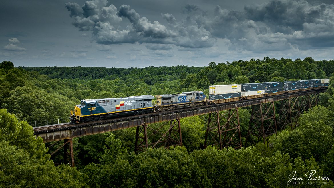 Well, today I caught my first one of the new CSX Heritage series locomotives, the Seaboard System unit, as it made its way across the Gum Lick Trestle, between Kelly and Crofton, Kentucky. It was leading CSX I026 northbound on the Henderson Subdivision on July 4th, 2023. I like how CSX is painting these units showing the new transitioning into the old.

According to Wikipedia: The Seaboard System Railroad, Inc. (reporting mark SBD) was a US Class I railroad that operated from 1982 to 1986.

Since the late 1960s, Seaboard Coast Line Industries had operated the Seaboard Coast Line and its sister railroadsnotably the Louisville & Nashville and Clinchfieldas the "Family Lines System". In 1980, SCLI merged with the Chessie System to create the holding company CSX Corporation; two years later, CSX merged the Family Lines railroads to create the Seaboard System Railroad.

In 1986, Seaboard renamed itself CSX Transportation, which absorbed the Chessie System's two major railroads the following year.

Tech Info: DJI Mavic 3 Classic Drone, RAW, 24mm, f/2.8, 1/2500, ISO 150.

#trainphotography #railroadphotography #trains #railways #dronephotography #trainphotographer #railroadphotographer #jimpearsonphotography #trains #csxt #mavic3classic #drones #trainsfromtheair #trainsfromadrone #CSXHeritageUnits