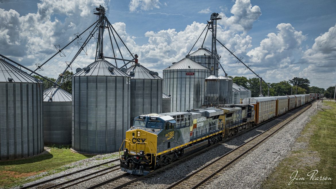 One of the new CSX Heritage series locomotives, the Seaboard System unit 1982, leads on CSX I025 as it heads south past the WF Ware grain storage tanks in Trenton, Ky, on July 6th, 2023, on the Henderson Subdivision.

According to Wikipedia: The Seaboard System Railroad, Inc. (reporting mark SBD) was a US Class I railroad that operated from 1982 to 1986.

Since the late 1960s, Seaboard Coast Line Industries had operated the Seaboard Coast Line and its sister railroadsnotably the Louisville & Nashville and Clinchfieldas the "Family Lines System". In 1980, SCLI merged with the Chessie System to create the holding company CSX Corporation; two years later, CSX merged the Family Lines railroads to create the Seaboard System Railroad.

In 1986, Seaboard renamed itself CSX Transportation, which absorbed the Chessie System's two major railroads the following year.

Tech Info: DJI Mavic 3 Classic Drone, RAW, 24mm, f/2.8, 1/3200, ISO 170.

#trainphotography #railroadphotography #trains #railways #dronephotography #trainphotographer #railroadphotographer #jimpearsonphotography #trains #csxt #mavic3classic #drones #trainsfromtheair #trainsfromadrone #CSXHeritageUnits