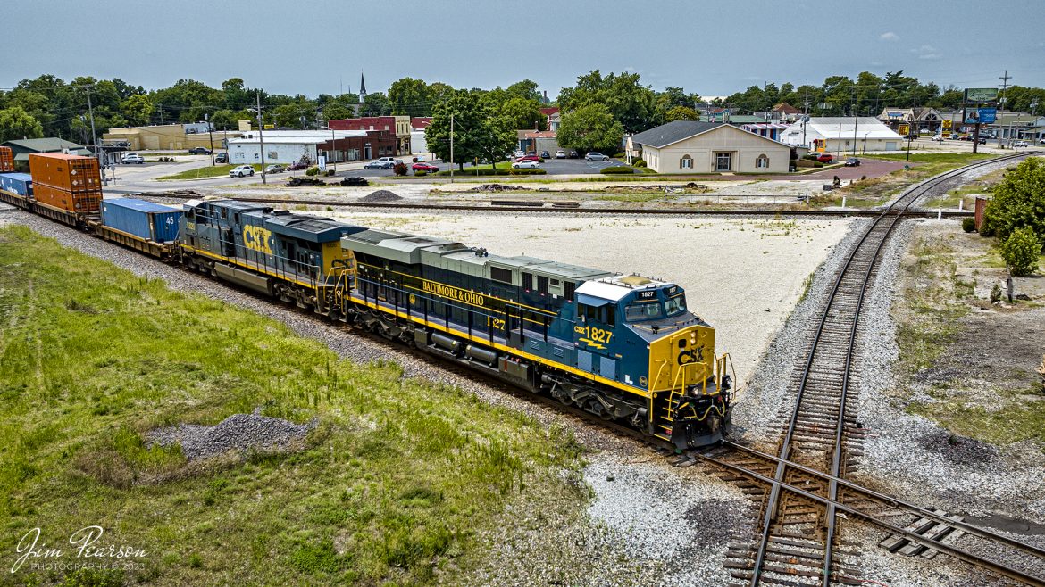 The new CSX Heritage series locomotive, the Baltimore & Ohio unit 1827, leads CSX hot intermodal I028 (one the CSX CE&D Sub) as it prepares to cross over the old B&O line (Illinois Subdivision) at Vincennes, Indiana, on July 17th, 2023. The old B&O Union Station and Hotel used to sit inside the wye you see pictured here.

According to Wikipedia: The Baltimore and Ohio Railroad was the first common carrier railroad and the oldest railroad in the United States with its first section opening in 1830.

The Chesapeake and Ohio Railway took financial control of the B&O in 1963.[52] On May 1, 1971, Amtrak had taken over all the remaining non-commuter routes of the B&O. The B&O already had a controlling interest in the Western Maryland Railway. In 1973 the three railroads were brought together under one corporate identity, the Chessie System, although they continued to operate as separate railroads. 

In 1980 the Chessie System and Seaboard Coast Line Industries, a holding company that owned the Seaboard Coast Line, the Louisville & Nashville, the Clinchfield, and the Georgia Railroad, agreed to form CSX Corporation. SCL Industries was renamed the Seaboard System Railroad (SBD) in 1983, the same year that the Western Maryland Railway was completely absorbed into the B&O. SBD was renamed CSX Transportation (CSX) in 1986. On April 30, 1987, the B&O's corporate existence ended when it was absorbed into the Chesapeake and Ohio Railway, which merged into CSX Transportation on August 31 of that year.

Tech Info: DJI Mavic 3 Classic Drone, RAW, 24mm, f/2.8, 1/2000, ISO 270.

#trainphotography #railroadphotography #trains #railways #dronephotography #trainphotographer #railroadphotographer #jimpearsonphotography #trains #csxt #mavic3classic #drones #trainsfromtheair #trainsfromadrone #CSXHeritageUnits