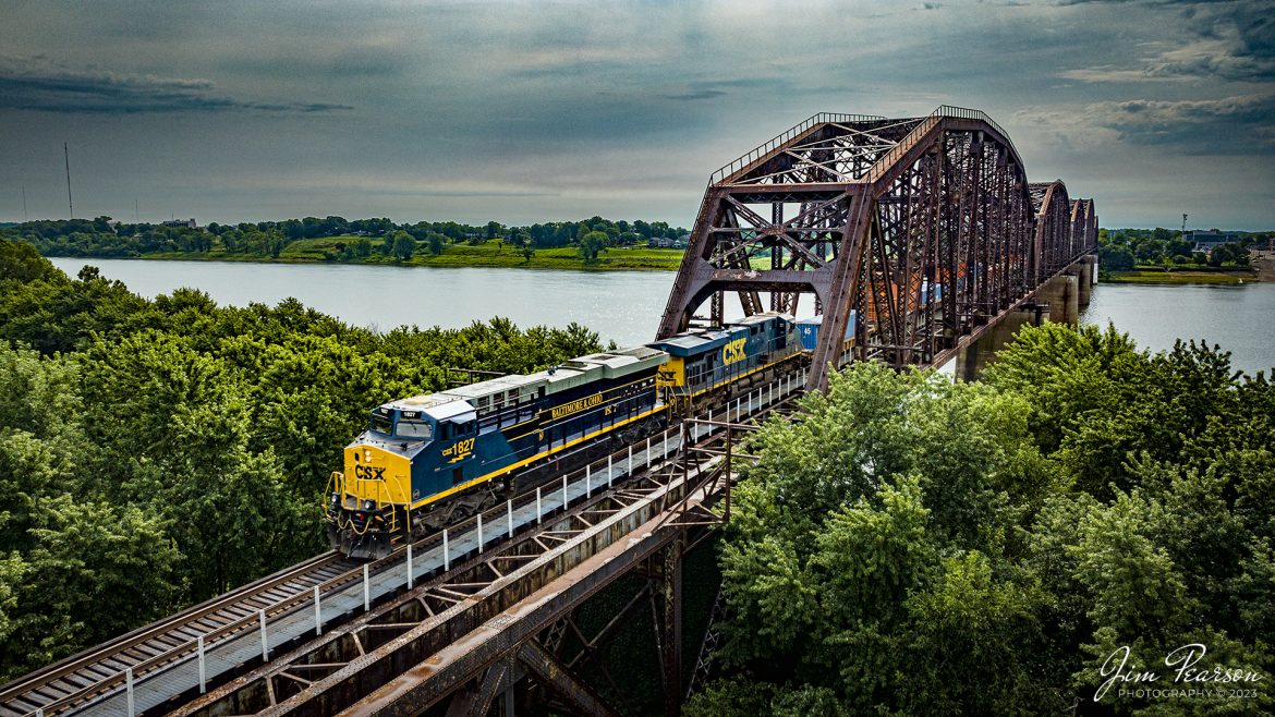 The new CSX Heritage series locomotive, the Baltimore & Ohio unit 1827, leads CSX hot intermodal I018 as it makes its way across the Ohio River from Henderson Kentucky on its northbound move on the Henderson Subdivision, on July 17th, 2023.

According to Wikipedia: The Baltimore and Ohio Railroad was the first common carrier railroad and the oldest railroad in the United States with its first section opening in 1830.

The Chesapeake and Ohio Railway took financial control of the B&O in 1963.[52] On May 1, 1971, Amtrak had taken over all the remaining non-commuter routes of the B&O. The B&O already had a controlling interest in the Western Maryland Railway. In 1973 the three railroads were brought together under one corporate identity, the Chessie System, although they continued to operate as separate railroads. 

In 1980 the Chessie System and Seaboard Coast Line Industries, a holding company that owned the Seaboard Coast Line, the Louisville & Nashville, the Clinchfield, and the Georgia Railroad, agreed to form CSX Corporation. SCL Industries was renamed the Seaboard System Railroad (SBD) in 1983, the same year that the Western Maryland Railway was completely absorbed into the B&O. SBD was renamed CSX Transportation (CSX) in 1986. On April 30, 1987, the B&O's corporate existence ended when it was absorbed into the Chesapeake and Ohio Railway, which merged into CSX Transportation on August 31 of that year.

Tech Info: DJI Mavic 3 Classic Drone, RAW, 24mm, f/2.8, 1/2000, ISO 210.

#trainphotography #railroadphotography #trains #railways #dronephotography #trainphotographer #railroadphotographer #jimpearsonphotography #trains #csxt #mavic3classic #drones #trainsfromtheair #trainsfromadrone #CSXHeritageUnits