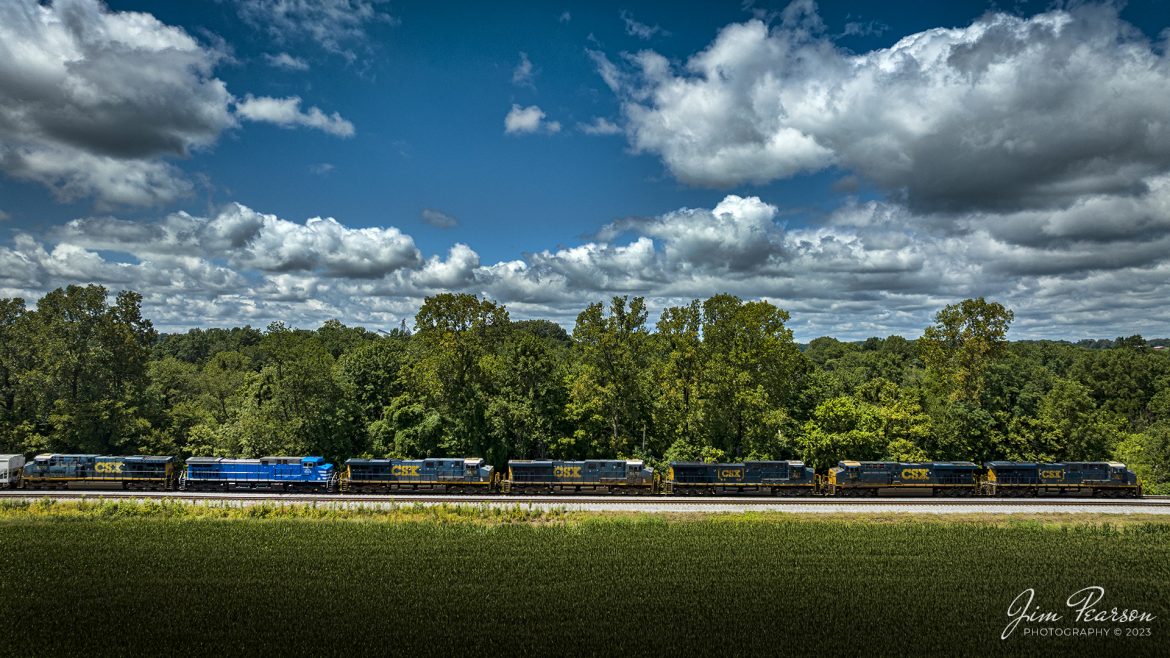 CSX M500 heads north at Slaughters, Kentucky, on the Henderson Subdivision, with 7 locomotives on the head end of their train on August 15th, 2023. Not all units were under power, and they were CSXT 983, 832, 237, 5472, 5418, CEFX 1055 and CSXT 5279. This is the power on the train that I featured in my Saturday Edited Video clip where the clip of this train cost me $500!

I had the tripod setup to record the trains passing through the north end of Slaughters as I captured this shot from my drone. After shooting this shot, I flew back to where I was at to land and while landing a gust of wind that blew through a string of empty lumber spine cars blew the tripod over and broke the screen big time on my iPhone 14 Pro, as I was tending to the landing of the drone. I should have let the drone hover till the train passed, but I wanted to get to another spot to catch it again and stepped about 6-8 feet away from the tripod, too far to catch it before it hit the ground.

The screen repair for the iPhone 14Pro was $450 plus tax and labor! Was I upset? Of course, but it’s the hazards of the game and so live and learn! Check out Episode 36 of my Saturday edited video if you’d like to watch the fall! Next time the drone hovers!

Tech Info: DJI Mavic 3 Classic Drone, RAW, 24mm, f/2.8, 1/3200, ISO 160.

#trainphotography #railroadphotography #trains #railways #dronephotography #trainphotographer #railroadphotographer #jimpearsonphotography #trains #csxt #mavic3classic #drones #trainsfromtheair #trainsfromadrone