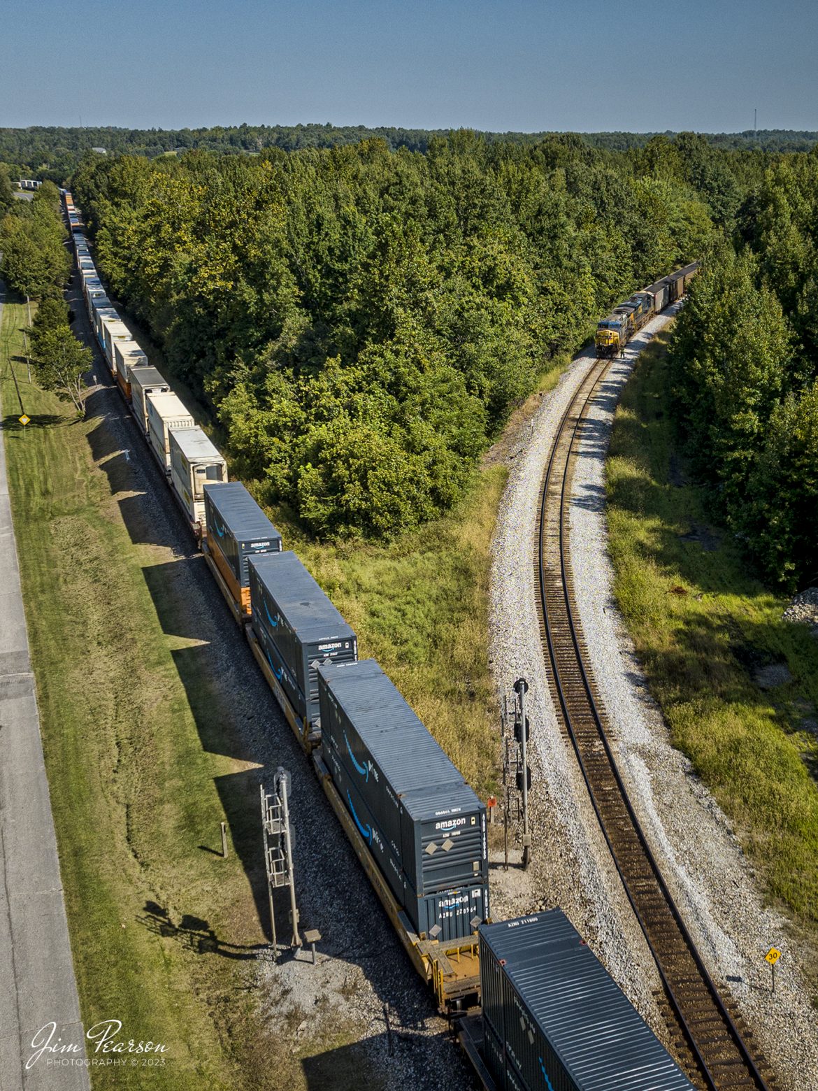 The conductor on loaded coal train C302 does a roll-by inspection of a northbound I028, as they wait on the on the cutoff at Mortons Junction on September 14th, 2023, for the hot intermodal to clear the main, so they can continue their run south on the CSX Henderson Subdivision.

Tech Info: DJI Mavic 3 Classic Drone, RAW, 22mm, f/8, 1/2000, ISO 130.

#trainphotography #railroadphotography #trains #railways #jimpearsonphotography #trainphotographer #railroadphotographer #dronephoto #trainsfromadrone #Kentuckytrains #csxhendersonsubdivision