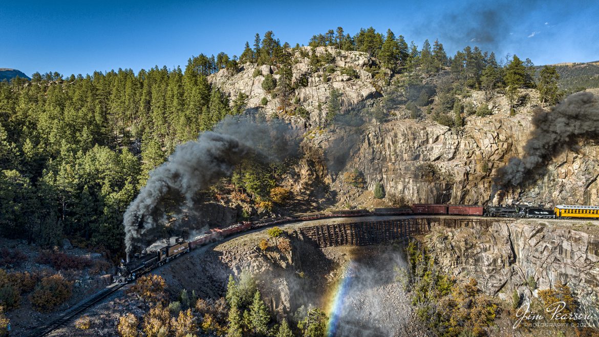 Denver and Rio Grande Western steam charter as locomotives 476 and mid-train helper 473 pull a freight and passenger train through Horseshoe Curve during our two-day charter between Durango and Silverton, Colorado on October 17th, 2023. The lead locomotive had just finished a blowdown, resulting in a rainbow in the steam cloud.

A blowdown is a way to get minerals and other contaminants out of the system. Engines want to be on a bridge or trestle because the blow down itself can reach 30+ feet at an angle away from the firebox with live steam.

According to Wikipedia: The Durango and Silverton Narrow Gauge Railroad, often abbreviated as the D&SNG, is a 3 ft (914 mm) narrow-gauge heritage railroad that operates on 45.2 mi (72.7 km) of track between Durango and Silverton, in the U.S. state of Colorado. The railway is a federally designated National Historic Landmark and was also designated by the American Society of Civil Engineers as a National Historic Civil Engineering Landmark in 1968.

Tech Info: DJI Mavic 3 Classic Drone, RAW, 22mm, f/2.8, 1/1000, ISO 500.

railroad, railroads train, trains, best photo. sold photo, railway, railway, sold train photos, sold train pictures, steam trains, rail transport, railroad engines, pictures of trains, pictures of railways, best train photograph, best photo, photography of trains, steam, train photography, sold picture, best sold picture, Jim Pearson Photography, Durango and Silverton Railroad