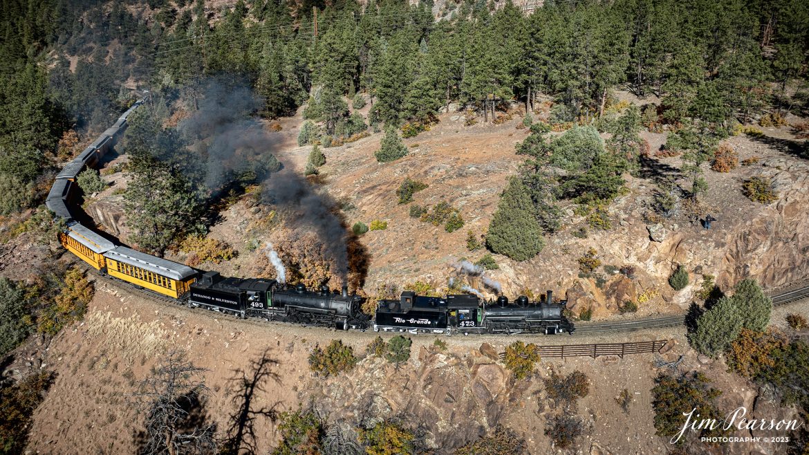 Denver and Rio Grande Western steam locomotives 473 and 493 head up a daily passenger train as they pull around the curve approaching Granite Point, just outside of Rockwood, Colorado, as they head to Silverton, CO, on October 15th, 2023. If you look closely at in the far-right center of the photo you’ll see the famous Big Diehl Photography who hiked into this point, perched on the mountain side, capturing the trains sights and sounds as it works upgrade!

According to Wikipedia: The Durango and Silverton Narrow Gauge Railroad, often abbreviated as the D&SNG, is a 3 ft (914 mm) narrow-gauge heritage railroad that operates on 45.2 mi (72.7 km) of track between Durango and Silverton, in the U.S. state of Colorado. The railway is a federally designated National Historic Landmark and was also designated by the American Society of Civil Engineers as a National Historic Civil Engineering Landmark in 1968.

Tech Info: DJI Mavic 3 Classic Drone, RAW, 22mm, f/2.8, 1/1250, ISO 100.

railroad, railroads train, trains, best photo. sold photo, railway, railway, sold train photos, sold train pictures, steam trains, rail transport, railroad engines, pictures of trains, pictures of railways, best train photograph, best photo, photography of trains, steam, train photography, sold picture, best sold picture, Jim Pearson Photography, Durango and Silverton Narrow Guage Railroad, steam train, DRGWRR, Trains from the air, drone