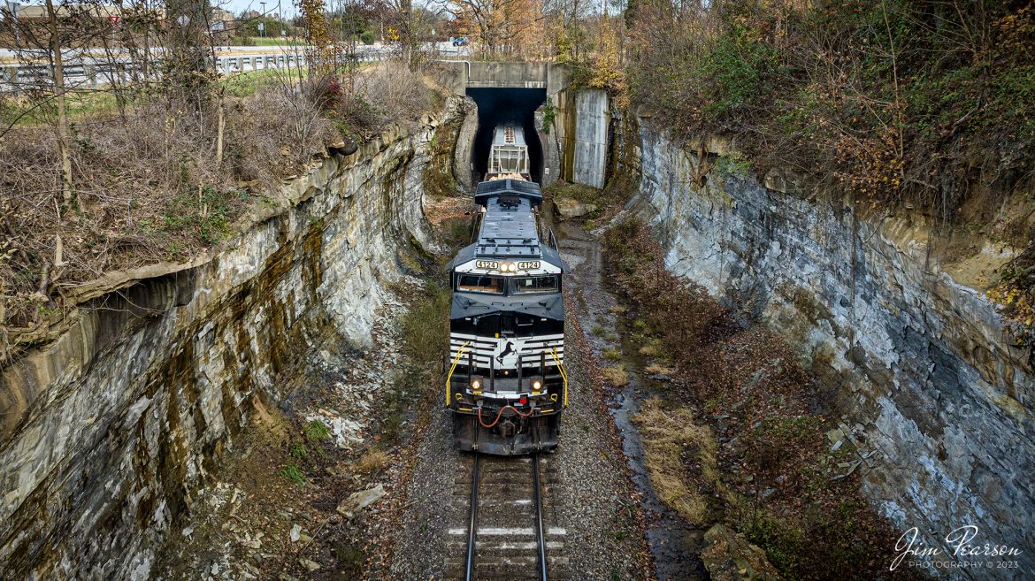 Norfolk Southern 4124 exits the Duncan Hill Tunnel as it leads NS 168 at Georgetown, Indiana on October 30th, 2023, as it heads west on the NS Southern East District.

According to Wikipedia: The Duncan Tunnel (also known as the Edwardsville Tunnel) is a railroad tunnel in Edwardsville, Floyd County, Indiana, USA. At 4,295 feet (1,309 m) long it is the longest tunnel in Indiana, nearly a mile long. The tunnel was initially built for the Air Line, who were unable to find a suitable route over the Floyds Knobs so they decided to tunnel through them. The tunnel was completed by the Southern Railway in 1881 at a total cost of $1 million. It is currently still in use by the Norfolk Southern Railway. The tunnel passes beneath I-64 intersection #118.

Tech Info: DJI Mavic 3 Classic Drone, RAW, 22mm, f/8, 1/1000, ISO 310.

#trainphotography #railroadphotography #trains #railways #jimpearsonphotography #trainphotographer #railroadphotographer #NSRailway #DuncanHillTunnel #dronephoto #trainsfromadrone #IndianaTrains #GeorgeTownIN