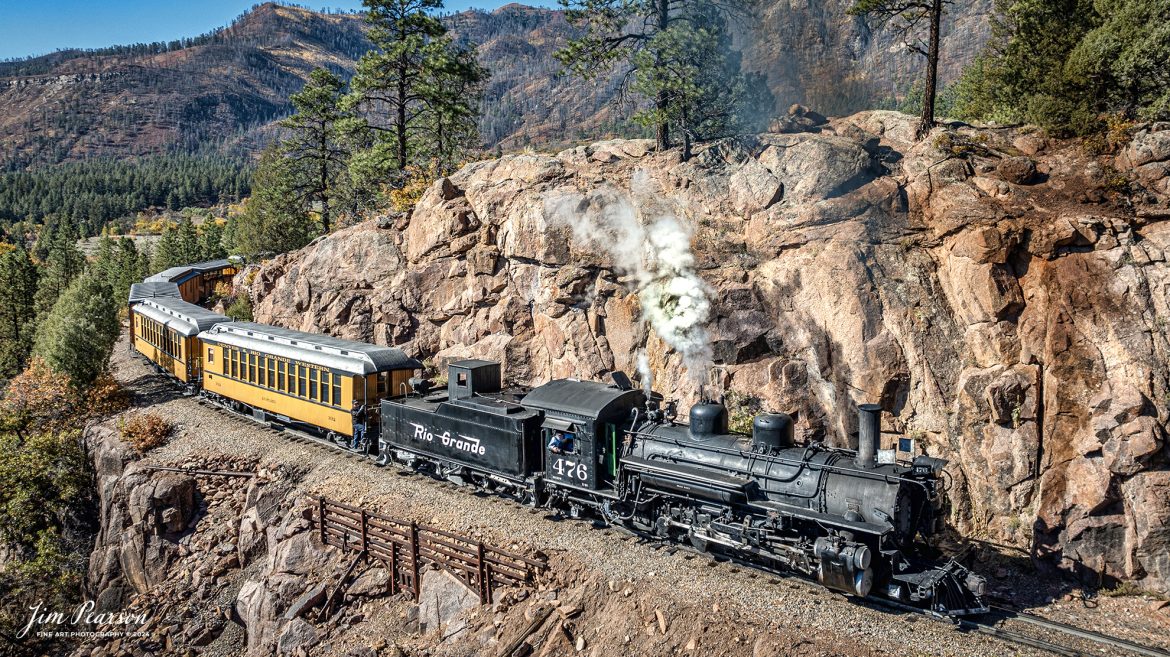 Denver and Rio Grande Western steam locomotive 476 leads a daily passenger train as they pull around Granite Point, just outside of Rockwood, Colorado, as they head to Silverton, CO, on October 15th, 2023. 

According to Wikipedia: The Durango and Silverton Narrow Gauge Railroad, often abbreviated as the D&SNG, is a 3 ft (914 mm) narrow-gauge heritage railroad that operates on 45.2 mi (72.7 km) of track between Durango and Silverton, in the U.S. state of Colorado. The railway is a federally designated National Historic Landmark and was also designated by the American Society of Civil Engineers as a National Historic Civil Engineering Landmark in 1968.

Tech Info: DJI Mavic 3 Classic Drone, RAW, 22mm, f/2.8, 1/1000, ISO 100.

#railroad #railroads #train, #trains #bestphoto #soldphoto #railway #railway #soldtrainphotos #steamtrains #railtransport #railroadengines #picturesoftrains #picturesofrailways #besttrainphotograph #bestphoto #photographyoftrains #steamtrainphotography #soldpicture #bestsoldpicture #JimPearsonPhotography #DurangoandSilvertonRailroad
