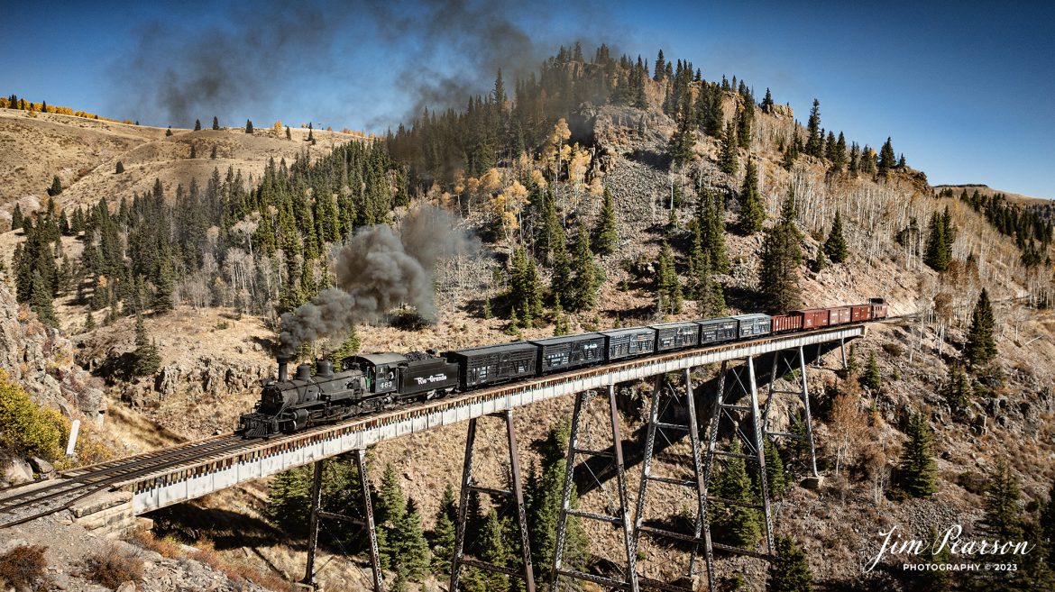 Cumbres & Toltec Scenic Railroad steam locomotive D&RGW 463 makes its way across High Bridge with a freight train on the way to Osier, Colorado, during a photo charter by Dak Dillon Photography on October 19th, 2023.

According to their website: the Cumbres & Toltec Scenic Railroad is a National Historic Landmark.  At 64-miles in length, it is the longest, the highest and most authentic steam railroad in North America, traveling through some of the most spectacular scenery in the Rocky Mountain West.

Owned by the states of Colorado and New Mexico, the train crosses state borders 11 times, zigzagging along canyon walls, burrowing through two tunnels, and steaming over 137-foot Cascade Trestle. All trains steam along through deep forests of aspens and evergreens, across high plains filled with wildflowers, and through a rocky gorge of remarkable geologic formations. Deer, antelope, elk, fox, eagles and even bear are frequently spotted on this family friendly, off-the grid adventure.

According to History Colorado Website: Built in 1903 by the Baldwin Locomotive Works of Philadelphia, Engine No. 463 is one of only two remaining locomotives of the K-27 series originally built for and operated by the Denver & Rio Grande Western Railroad.

The K-27 series was a departure from the design most prevalent on Colorado’s narrow-gauge lines, resulting in a locomotive with one and one-half times more power.  The arrival of this series marked a significant turning point in the operation of the D&RGW’s narrow gauge lines that was to remain in effect until the end of Class I narrow gauge steam locomotion in 1968.  The Friends of the Cumbres & Toltec Scenic Railroad restored the engine to operating condition.

Tech Info: DJI Mavic 3 Classic Drone, RAW, 22mm, f/2.8, 1/1250, ISO 100.

railroad, railroads train, trains, best photo. sold photo, railway, railway, sold train photos, sold train pictures, steam trains, rail transport, railroad engines, pictures of trains, pictures of railways, best train photograph, best photo, photography of trains, steam, train photography, sold picture, best sold picture, Jim Pearson Photography, Cumbres & Toltec Scenic Railroad, steam train, CTSRR, Trains from the air, drone