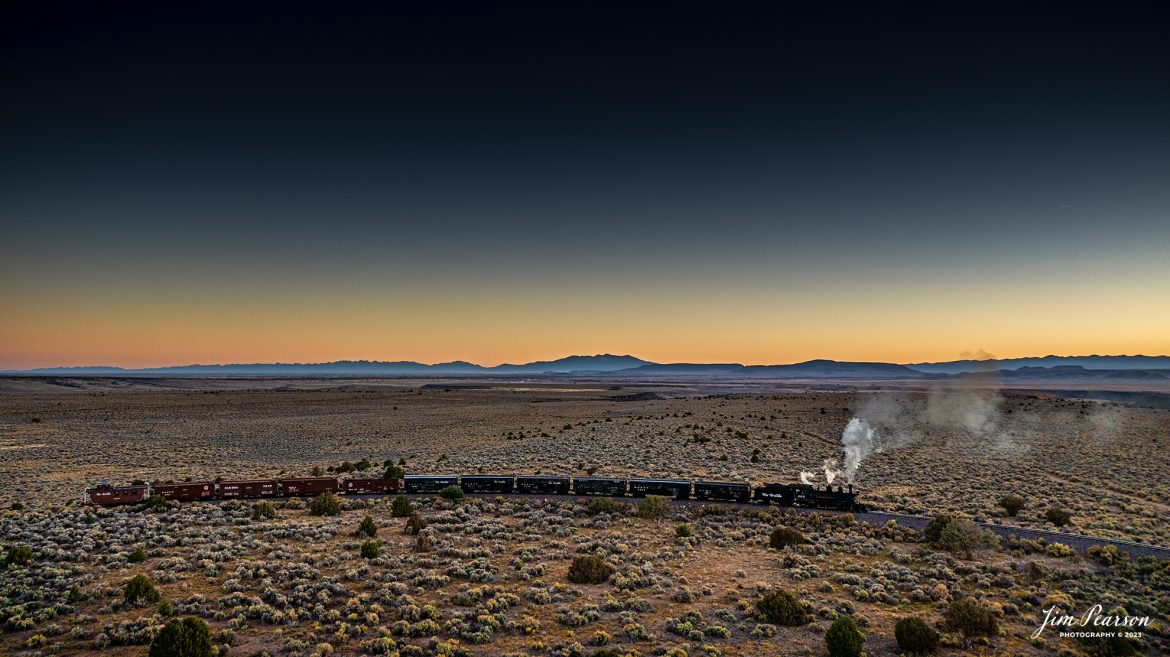 The glow of the morning sun illuminates the horizon as Cumbres & Toltec Scenic Railroad steam locomotive D&RGW 463 makes its way through the Lava Curve with a freight train on the way to Osier, Colorado, during a photo charter by Dak Dillon Photography on October 19th, 2023.

According to their website: the Cumbres & Toltec Scenic Railroad is a National Historic Landmark.  At 64-miles in length, it is the longest, the highest and most authentic steam railroad in North America, traveling through some of the most spectacular scenery in the Rocky Mountain West.

Owned by the states of Colorado and New Mexico, the train crosses state borders 11 times, zigzagging along canyon walls, burrowing through two tunnels, and steaming over 137-foot Cascade Trestle. All trains steam along through deep forests of aspens and evergreens, across high plains filled with wildflowers, and through a rocky gorge of remarkable geologic formations. Deer, antelope, elk, fox, eagles and even bear are frequently spotted on this family friendly, off-the grid adventure.

According to History Colorado Website: Built in 1903 by the Baldwin Locomotive Works of Philadelphia, Engine No. 463 is one of only two remaining locomotives of the K-27 series originally built for and operated by the Denver & Rio Grande Western Railroad.

The K-27 series was a departure from the design most prevalent on Colorado’s narrow-gauge lines, resulting in a locomotive with one and one-half times more power.  The arrival of this series marked a significant turning point in the operation of the D&RGW’s narrow gauge lines that was to remain in effect until the end of Class I narrow gauge steam locomotion in 1968.  The Friends of the Cumbres & Toltec Scenic Railroad restored the engine to operating condition.

Tech Info: DJI Mavic 3 Classic Drone, RAW, 22mm, f/2.8, 1/160, ISO 170.

railroad, railroads train, trains, best photo. sold photo, railway, railway, sold train photos, sold train pictures, steam trains, rail transport, railroad engines, pictures of trains, pictures of railways, best train photograph, best photo, photography of trains, steam, train photography, sold picture, best sold picture, Jim Pearson Photography, Cumbres & Toltec Scenic Railroad, steam train, CTSRR, Trains from the air, drone