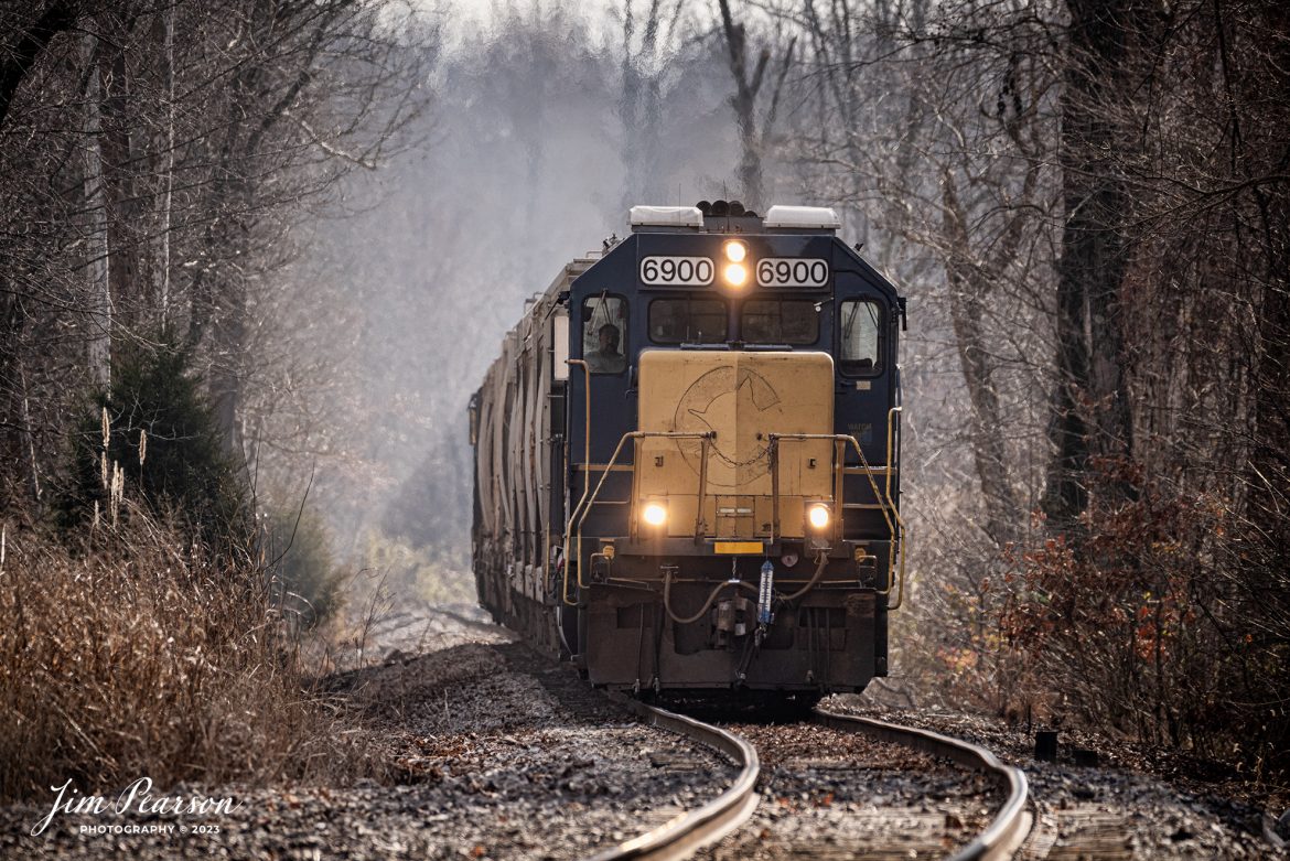 CSX 6900 L285, GP 40-2, ex Chessie C&O 4392, with the faint outline of the Chessie Cat logo on the front of the nose, makes its way back toward Madisonville, Ky on the  MH&E Branch, as it approaches the Paducah and Louisville Railway at Central City, Ky. This unit has been also known as "Blank face" and "No logo nose" On December 6th, 2023.

From what I found online: for context, Chessie System was the combination of the Baltimore and Ohio Railroad, The Chesapeake and Ohio Railway, and the Western Maryland Railway. The Hagerstown yard was once part of the WM, home to a major classification yard and locomotive repair facility. The name came from C&O, who took majority control over the B&O and WM. CSX dates to 1980 as a joint venture between Chessie and Seaboard System before formally merging in 1986.

6900 was indeed part of the former Chessie System (for the C&O specifically) and wore the same logo on her nose when she was built in 1980. However, this is not her old colors showing through. After some repair work in 2018/2019, 6900 lost her CSX decal, leaving a blank nose. In 2020, a crew in Ohio took it upon themselves to apply the Chessie logo as a nod to her heritage, however it was removed shortly after, leaving this faded "ghostly" image.

CSX L285 is on a return trip from making a pickup at HARSCO, BLACK BEAUTY Abrasives (Reed Minerals) at Drakesboro, Ky on the CSX MH&E Branch. CSX uses a short portion of this branch to service the plant, with it being its only customer on it. At Central City they switch onto the Paducah and Louisville Railway and return on the PAL to Madisonville, Ky.

Tech Info: Nikon D810, RAW, Sigma 150-600 @ 460mm, f/6, 1/800, ISO 320.

#trainphotography #railroadphotography #trains #railways #trainphotographer #railroadphotographer #jimpearsonphotography #NikonD810 #KentuckyTrains #CSXMHEBranch #csxt