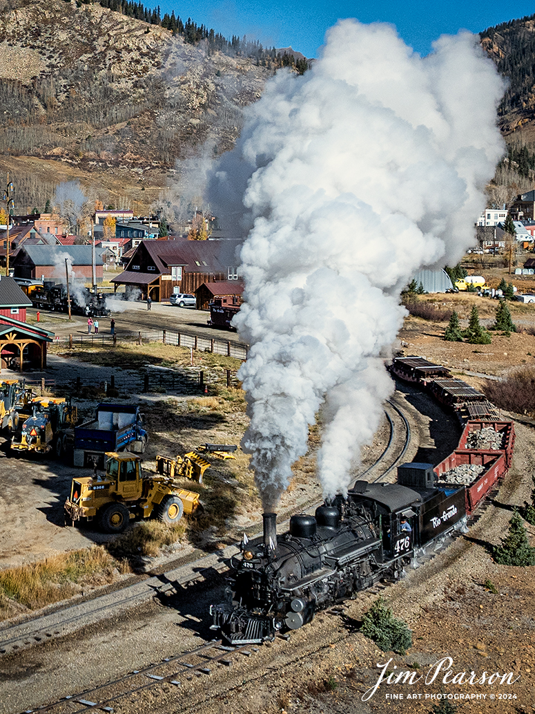 Denver and Rio Grande Western 476 departs Silverton, Colorado, on October 17th, 2023, as they head back toward Durango with a freight train, as part of their annual photography charter. 

According to Wikipedia: The Durango and Silverton Narrow Gauge Railroad, often abbreviated as the D&SNG, is a 3 ft (914 mm) narrow-gauge heritage railroad that operates on 45.2 mi (72.7 km) of track between Durango and Silverton, in the U.S. state of Colorado. The railway is a federally designated National Historic Landmark and was also designated by the American Society of Civil Engineers as a National Historic Civil Engineering Landmark in 1968.

Tech Info: DJI Mavic 3 Classic Drone, RAW, 22mm, f/2.8, 1/4000, ISO 160.

#railroad #railroads #train, #trains #bestphoto #soldphoto #railway #railway #soldtrainphotos #steamtrains #railtransport #railroadengines #picturesoftrains #picturesofrailways #besttrainphotograph #bestphoto #photographyoftrains #steamtrainphotography #soldpicture #bestsoldpicture #JimPearsonPhotography #DurangoandSilvertonRailroad