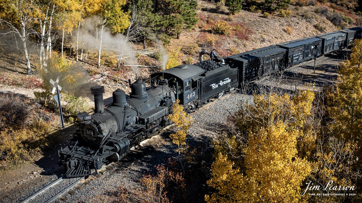 Cumbres & Toltec Scenic Railroad steam locomotive D&RGW 463 takes on water at Sublette, NM, during a photo charter by Dak Dillon Photography on October 19th, 2023.

According to their website: the Cumbres & Toltec Scenic Railroad is a National Historic Landmark.  At 64-miles in length, it is the longest, the highest and most authentic steam railroad in North America, traveling through some of the most spectacular scenery in the Rocky Mountain West.

Owned by the states of Colorado and New Mexico, the train crosses state borders 11 times, zigzagging along canyon walls, burrowing through two tunnels, and steaming over 137-foot Cascade Trestle. All trains steam along through deep forests of aspens and evergreens, across high plains filled with wildflowers, and through a rocky gorge of remarkable geologic formations. Deer, antelope, elk, fox, eagles and even bear are frequently spotted on this family friendly, off-the grid adventure.

The K-27 series was a departure from the design most prevalent on Colorado’s narrow-gauge lines, resulting in a locomotive with one and one-half times more power.  The arrival of this series marked a significant turning point in the operation of the D&RGW’s narrow gauge lines that was to remain in effect until the end of Class I narrow gauge steam locomotion in 1968.  The Friends of the Cumbres & Toltec Scenic Railroad restored the engine to operating condition.

Tech Info: DJI Mavic 3 Classic Drone, RAW, 22mm, f/2.8, 1/1600, ISO 100.

#trainphotography #railroadphotography #trains #railways #jimpearsonphotography #trainphotographer #railroadphotographer #CumbresamdToltecScenicRailroad