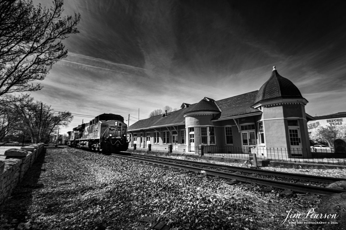 In this week’s Saturday Infrared Photo, CSXT 5351 leads intermodal train, I128, past the old Louisville and Nashville (L&N) Railroad Depot. on the Henderson Subdivision as they head north on February 21st, 2024.

According to Wikipedia: “The L&N Railroad Depot in the Hopkinsville Commercial Historic District of Hopkinsville, Kentucky is a historic railroad station on the National Register of Historic Places. It was built by the Louisville & Nashville Railroad in 1892.

The year 1832 saw the first of many attempts to woo a railroad to Hopkinsville. This first attempt was to connect Hopkinsville to Eddyville, Kentucky. In 1868 Hopkinsville finally obtained a railroad station, operated by the Evansville, Henderson, & Nashville Railroad. The Louisville & Nashville Railroad acquired the railroad in 1879.

The Hopkinsville depot is a single-story frame building with a slate roof. It has six rooms: A Ladies Waiting room (the room closest to the street), a General Waiting Room, a Colored Waiting Room, a baggage room (the furthest room from the street), a ticket office (the only room which connected to all three waiting rooms), and a ladies’ restroom. Immediately outside were warehouses for freight, usually tobacco.

Its last long-distance (passenger) train was the Louisville and Nashville’s Georgian, last operating in 1968.

During its operating years, the Hopkinsville depot was a popular layover spot for those traveling by train. It was the only Louisville & Nashville station between Evansville, Indiana and Nashville, Tennessee where it was legal to drink alcohol. Hopkinsville got the nickname “Hop town” due to train passengers asking the conductors when they would arrive at Hopkinsville, so they could “hop off and get a drink”.

The Hopkinsville L&N Railroad Depot was placed on the National Register of Historic Places on August 1, 1975. CSX, which bought out the Louisville & Nashville, still run trains on the tracks next to the depot, but do not stop.”

Tech Info: Fuji XT-1, RAW, Converted to 720nm B&W IR, Nikon 10-24 @ 10mm, f/5.6, 1/340, ISO 400.

#trainphotography #railroadphotography #trains #railways #jimpearsonphotography #infraredtrainphotography #infraredphotography #trainphotographer #railroadphotographer #csxrailroad #infraredphotography #trending