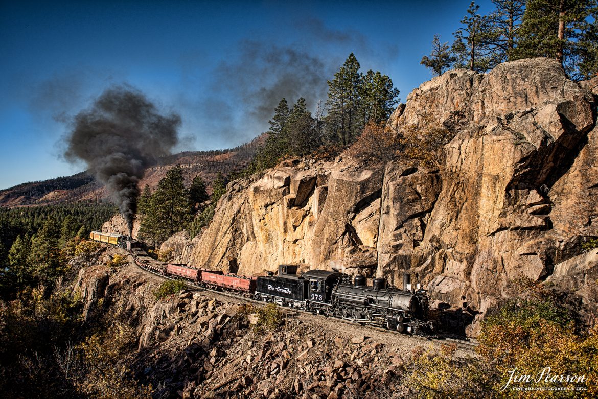 Durango and Silverton Narrow Gauge steam locomotive D&RGW 473 pulls a K-28 100th Anniversary Special with D&RGW 476 as a mid-train helper through the Repeating Curves at MP 472.2, along the Animas River, between Durango and Silverton, Colorado, on October 16th, 2023.

According to Wikipedia: The Durango and Silverton Narrow Gauge Railroad, often abbreviated as the D&SNG, is a 3 ft (914 mm) narrow-gauge heritage railroad that operates on 45.2 mi (72.7 km) of track between Durango and Silverton, in the U.S. state of Colorado. The railway is a federally designated National Historic Landmark and was also designated by the American Society of Civil Engineers as a National Historic Civil Engineering Landmark in 1968.

Tech Info: Nikon D810, RAW, Sigma 24-70 @ 24mm, f/5.6, 1/640, ISO 160.

railroad, railroads train, trains, best photo. sold photo, railway, railway, sold train photos, sold train pictures, steam trains, rail transport, railroad engines, pictures of trains, pictures of railways, best train photograph, best photo, photography of trains, steam, train photography, sold picture, best sold picture, Jim Pearson Photography, Durango and Silverton Narrow Guage Railroad, steam train, DRGWRR
