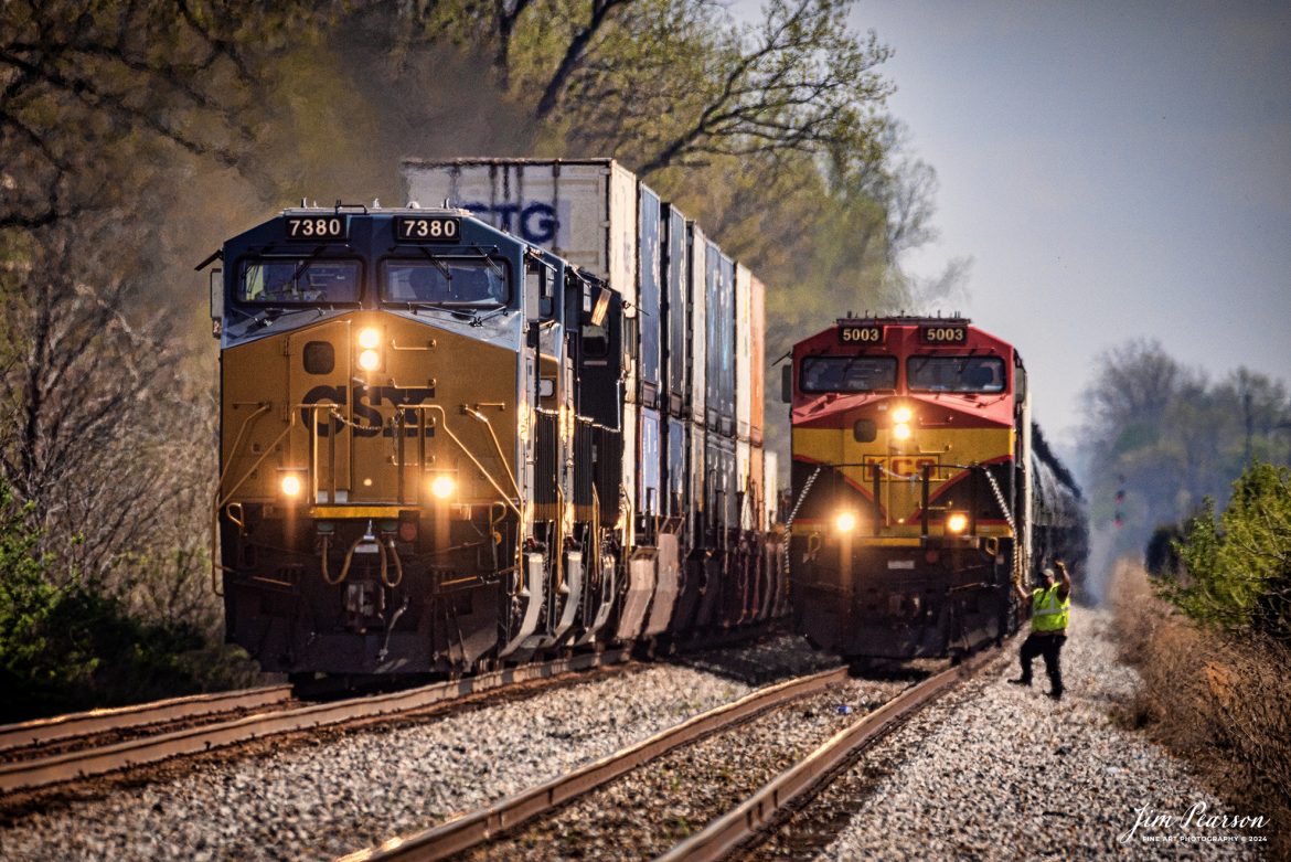 The conductor on KCS 5003 gives a friendly wave to the crew of the passing I026 as he prepares to conduct a roll-by inspection, as he waits for it to pass so his train, B622 can pull out of the siding at the north end of Rankin, Ky behind the intermodal and continue their move north on April 8th, 2024, on the CSX Henderson Subdivision.

Tech Info: Nikon D810, RAW, 150-600mm @600, f/6.3, 1/2500, ISO 80.