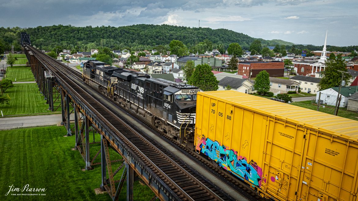 A Norfolk Southern mixed freight approaches the old N&W Bridge over the Ohio River on the Kenova District as it heads westbound at Kenova, on May 2nd, 2025.

According to Wikipedia, the bridge was first completed in 1892 with a single track, but its piers were sized for future widening. The expansion to two tracks was undertaken in 1913 by Norfolk and Western, the predecessor railway of the current owner, Norfolk Southern. The railroad added new trusses around the existing structure and expanded the piers. Rail traffic continued throughout construction, and the new tracks opened on June 9, 1913.

Tech Info: DJI Mavic 3 Classic Drone, RAW, 24mm, f/2.8, 1/1600, ISO 220.

#railroad #railroads #train, #trains #railway #railway #railtransport #railroadengines #picturesoftrains #picturesofrailways #besttrainphotograph #bestphoto #photographyoftrains #bestsoldpicture #JimPearsonPhotography #trainsfromtheair #trainsfromadrone #norfolksouthern