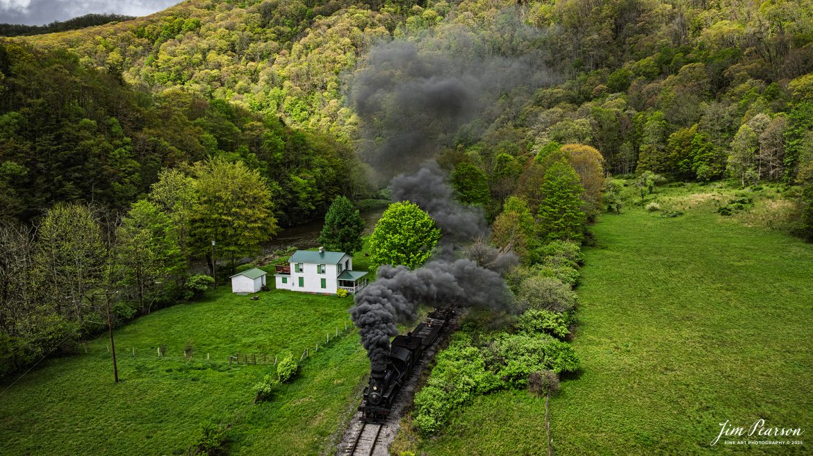 Cass Scenic Railway Heisler #6 pulls through the countryside passing a small white house at milepost 92 on the way to Durban, West Virginia, during the Cass Spring Photographers Special, out of Cass, West Virgina on May 4th, 2025. 

According to the Mountain Rail West Virgina Website: The Meadow River Lumber No. 6 was built by the Heisler Locomotive Works in Erie, PA, in 1929 for the Bostonia Coal & Clay Products Company of New Bethlehem, PA.

The Heisler was sold to the Meadow River Lumber Company at Rainelle, WV in 1939, where it was rostered as No. 6. She retired from the lumber company in 1965 and was purchased by the purchased it by the state of West Virginia purchased. The engine ran under its own steam from Rainelle to its new home in Cass in December 1966. No. 6 would begin operating on the railroad in 1968. The Heisler is the fastest geared locomotive in the Cass collection.

Tech Info: DJI Mavic 3 Classic Drone, RAW, 24mm, f/6.3, 1/1000, ISO 100.

#railroad #railroads #train, #trains #railway #railway #steamtrains #railtransport #railroadengines #picturesoftrains #picturesofrailways #besttrainphotograph #bestphoto #photographyoftrains #bestsoldpicture #JimPearsonPhotography #trainsfromtheair #trainsfromadrone #steamtrain #casssenicrailway