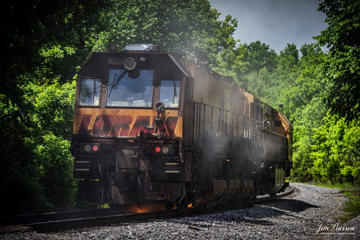 LORAM Railgrinder 56 grinds a grade crossing as it heads south at Dawson Springs, Kentucky,on the Paducah and Louisville Railway, on June 5th, 2025.

According to Wikipedia: A rail grinder (or rail grinder) is a maintenance of way vehicle or train used to restore the profile and remove irregularities from worn tracks to extend its life and to improve the ride of trains using the track.

Tech Info: Nikon D810, RAW, Nikon 70-300 @ 150mm, f/5, 1/1600, ISO 400.

#railroad #railroads #train, #trains #railway #railway #steamtrains #railtransport #railroadengines #picturesoftrains #picturesofrailways #besttrainphotograph #bestphoto #photographyoftrains #bestsoldpicture #JimPearsonPhotography #Brightline #passengertrains #trainsfromtheair #trainsfromadrone #loram