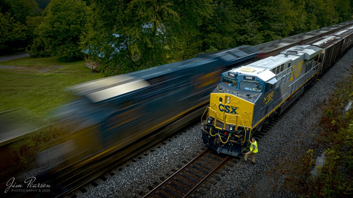 The late evening light and rainy weather helped bring about this slow shutter speed shot of the conductor on G419, with the latest CSX Heritage Unit, L&N 1850 leading his loaded grain train, doing a roll-by inspection on empty coal train E904 at the south end of the siding at Slaughters, Kentucky on October 5th, 2023, on the Henderson Subdivision, trackage that used to belong to the L&N.

I’ve been trying for several days to get a good shot of this engine, as it’s been at Howell Yard in Evansville, IN for their Family Days event. I didn’t want a shot of it just sitting in a yard, so I played the long game and made two-day long trips to Indiana to get it finally on the move! I started the chase on this move at Princeton, IN this was my last shot of the day! It rained pretty much the whole day, but fortunately there was a lull here and a couple of other spots where I was able to get the drone up!

According to CSXT: CSX has introduced the sixth locomotive in its heritage series, a freshly painted unit honoring the Louisville & Nashville Railroad. Designated CSX 1850, the locomotive will be placed into service, carrying the L&N colors across the 20,000-mile CSX network.

The paint scheme was designed and applied at the CSX Locomotive Shop in Waycross, Georgia, which has produced all six units in the heritage series celebrating the lines that came together to form the modern CSX. Like the other heritage locomotives, the L&N unit combines the heritage railroad’s iconic logo and colors on the rear two-thirds of the engine with today’s CSX colors and markings on the cab end.

Chartered by the State of Kentucky in 1850, the L&N grew into a vital transportation link between the Gulf Coast and the nation’s heartland. The railroad was absorbed by the Seaboard Coast Line Railroad, which subsequently became part of the Chessie System and, ultimately, today’s CSX.

The CSX heritage series is reinforcing employee pride in the history of the railroad that continues to move the nation’s economy with safe, reliable and sustainable rail-based transportation services.

Tech Info: DJI Mavic 3 Classic Drone, RAW, 22mm, f/8, 1/10, ISO 100.

#trainphotography #railroadphotography #trains #railways #jimpearsonphotography #trainphotographer #railroadphotographer #CSXHeritage #SlaughtersKy #dronephoto #trainsfromadrone #KyTrains