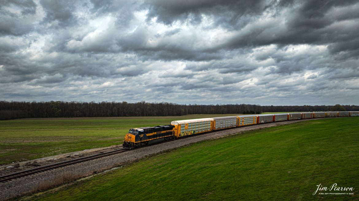 CSX I025 heads south at Breton, Kentucky as CSX Monon Heritage Unit 1897 leads it under dark threatening skies on April 2nd, 2025, on the CSX Henderson Subdivision. The eleven autoracks behind the engine are loaded with Tesla’s bound for Florida and overseas market from what I’m told.

Capturing this engine means I’ve caught all of CSX’s Heritage units except for the Georgia Heritage Unit, and that one is only a matter of time!

According to a CSX Press Release: January 26, 2024 - In a tribute to its rich railroad history, CSX has unveiled its Monon 1897 heritage locomotive, marking the ninth release its ongoing heritage series honoring the company's predecessor railroads.

“The Monon Railroad ran from Chicago down to Louisville but most of it was in Indiana,” explained CSX Carman Jason Merritt, who assisted with the heritage project. “Eventually it merged with the Louisville and Nashville Lines and was later absorbed by CSX.”

The new heritage locomotive emerges fresh from the Class I railroad's paint shop in Waycross, Ga., showcasing a blend of modern and historic aesthetics. The design features the modern CSX design on the head end, transitioning seamlessly into the historic paint scheme and logo of the Monon line. This style reflects the approach taken with previous installations in the CSX heritage series, which often feature the current CSX paint scheme on the nose and the predecessor's scheme on the body.

“A lot of hard work and planning goes into each project,” said Merritt. “We want to get these right, so we take pride in what we do, from the wash rack to moving them out the door.”

The new Monon heritage locomotive is a testament to the enduring legacy of America's railroads. It stands as a symbol of the past while simultaneously pointing towards the future, embodying the spirit of evolution and innovation that drives CSX.

Tech Info: DJI Mavic 3 Classic Drone, RAW, 22mm, f/2.8, 1/2000, ISO 130.

#railroad #railroads #train, #trains #railway #railway #railtransport #railroadengines #picturesoftrains #picturesofrailways #besttrainphotograph #bestphoto #photographyoftrains #bestsoldpicture #JimPearsonPhotography #trainsfromadrone #csxhendersonsubdivision #onecsx #csxheritageunit