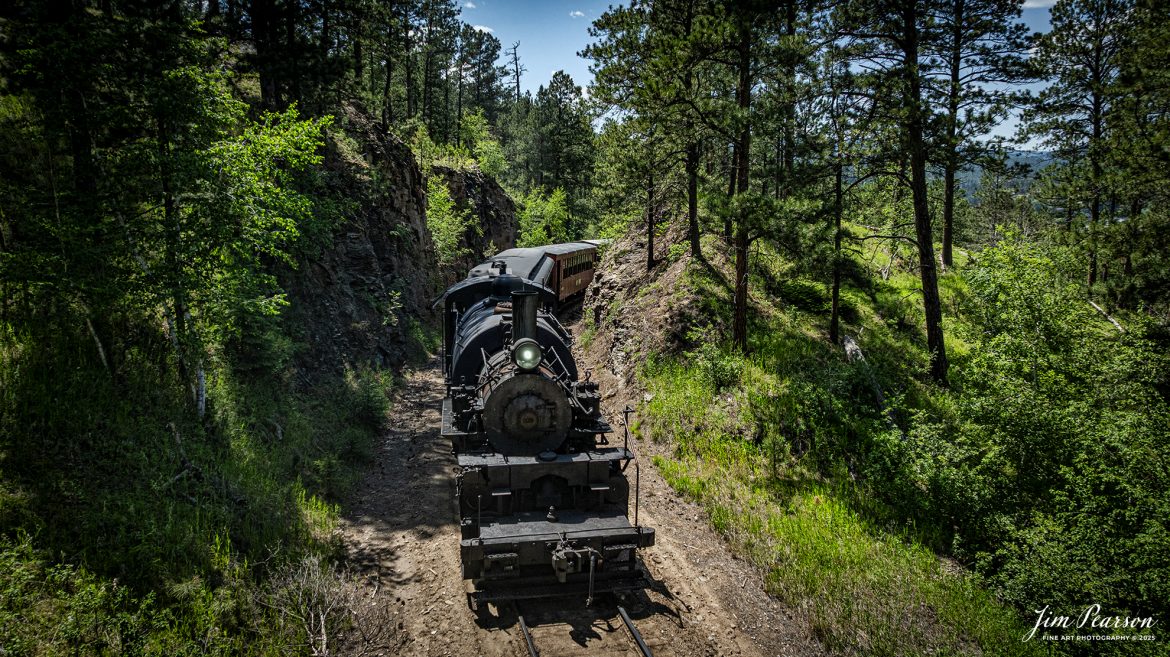 The Black Hills Central Railway locomotive 108 works their way through one of many rock cuts through the Black Hills countryside as it makes its third trip of the day between Hill City to Keystone, South Dakota, on June 26th, 2025. A big shout out to Cory Jakeway for all the help on finding my way around on the railroad and railfanning with me!

According to their website: Locomotive is a 2-6-6-2T articulated tank engine that was built by the Baldwin Locomotives Works in 1926 for the Potlatch Lumber Company. It later made its way to Weyerhaeuser Timber Company and eventually to the Northwest Railway Museum in Snoqualmie, Washington.

The acquisition and subsequent restoration of locomotive 108 completed a more than 20-year goal of increasing passenger capacity which began with the restoration of 110 and the restoration of multiple passenger cars. Both large Mallet locomotives (pronounced “Malley”) can pull a full train of seven authentically restored passenger cars, up from the four cars utilized prior to their addition to the roster.

Tech Info: DJI Mavic 3 Classic Drone, RAW, 24mm, f/2.8, 1/2500, ISO 150.

#railroad #railroads #train, #trains #railway #railway #steamtrains #railtransport #railroadengines #picturesoftrains #picturesofrailways #besttrainphotograph #bestphoto #photographyoftrains #bestsoldpicture #JimPearsonPhotography #trainsfromtheair #trainsfromadrone #1880train #steamtrain #blackhills