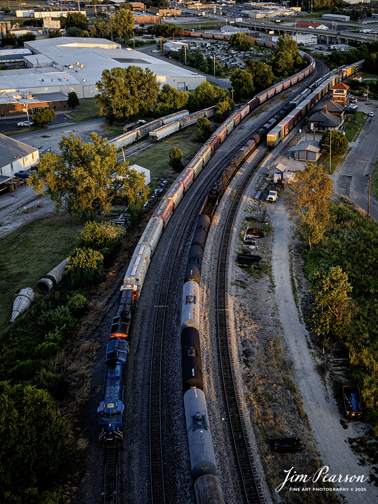 This isn’t the shot I had planned for this train, and the day for this train didn’t go as planned for the crew either!

I waited across the river at Henderson, Kentucky for this B237 phosphate loads, which were scheduled to take the Texas Line here at Henderson, Ky, but wires got crossed and their train was sent south along the Henderson Subdivision, until the dispatcher realized they were supposed to take the Texas line to Louisville, Ky.

So, the train went to the siding at Rankin, which is about 5 miles south of Henderson where the crew ran their power around the train and then pulled their loads back through Henderson. Then they backed their train onto the Texas Line, which you can see snaking off in the distance to the left. 

They then sat there to allow a few trains to get by as they were blocking the main. After this shot, which I didn’t wait for as it was dark, they ran back around their train and took it onto Louisville. 

A missed thrown switch and light cost this crew and train an extra 3 or more hours as that’s how long it took for all this to happen.

There’s a draw bridge at Spottsville, Ky where I sat for two of those hours waiting to photograph him at. There’ll be others though and some days it goes like this!

The old L&N Depot is in the upper right corner of this shot and is currently under restoration.

The blue engine is GECX 2038, and the other is Canadian National 3281.

Tech Info: DJI Mavic 3 Classic Drone, RAW, 22mm, f/2.8, 1/100, ISO 140

#railroad #railroads #train, #trains #railway #railway #railtransport #railroadengines #picturesoftrains #picturesofrailways #besttrainphotograph #bestphoto #photographyoftrains #bestsoldpicture #JimPearsonPhotography #trainsfromtheair #trainsfromadrone #onecsx #csx