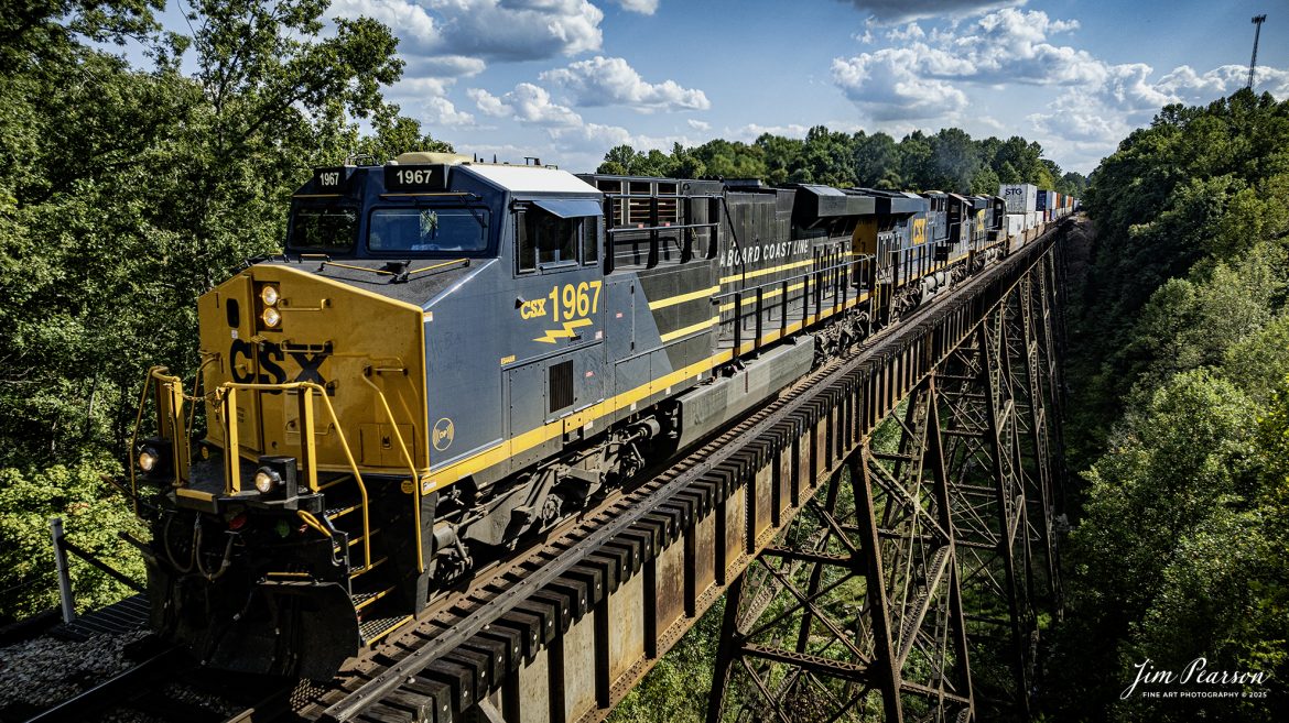CSX Seaboard Coast Line Railroad Heritage Unit 1967 heads north across the Gum Lick Trestle leading CSX I026, just north of Kelly, Kentucky on September 9th, 2025, on the CSX Henderson Subdivision.

According to a CSX Press Release: May 23, 2024 – CSX Transportation has launched its newest heritage locomotive, paying tribute to the Seaboard Coast Line Railroad (SCL). This latest addition is part of CSX’s ongoing initiative to honor its historical roots while paving the way for the future of railroading in America.

The Seaboard Coast Line Railroad (SCL) was a prominent rail line that operated in the southeastern United States from 1967 until 1983. SCL emerged from the merger of the Seaboard Air Line Railroad and the Atlantic Coast Line Railroad. In 1986, SCL became part of CSX through a series of mergers and acquisitions that formed one of the largest Class I railroads in North America.

“When SCL was an active railroad, it was the eighth largest railroad with almost 10,000 miles across the southern United States,” explained CSX Carman Painter Jason Merritt, one of the team members who worked on the project. “In fact, the ‘S’ in CSX actually stands for Seaboard.”

Tech Info: DJI Mavic 3 Classic Drone, RAW, 22mm, f/2.8, 1/2500, ISO 220

#railroad #railroads #train, #trains #railway #railway #railtransport #railroadengines #picturesoftrains #picturesofrailways #besttrainphotograph #bestphoto #photographyoftrains #bestsoldpicture #JimPearsonPhotography #trainsfromtheair #trainsfromadrone #onecsx #csx