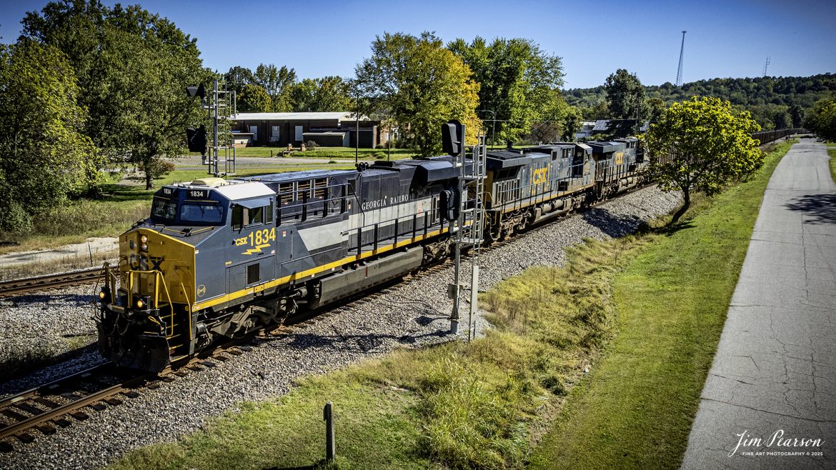 CSXT 1834 Georgia Railroad Heritage Unit leads E904 as they head north through Mortons Junction at Mortons Gap, Kentucky, on October 14th, 2025, on the CSX Henderson Subdivision. 

I thought capturing this unit had finished up my goal of capturing all the current CSX Heritage Units but looking over my records I still have yet to capture the 1902 Clinchfield locomotive and so the hunt continues!

According to a CSXT Press Release: June 27, 2024 - CSX has unveiled a new heritage locomotive honoring the legacy of the Georgia Railroad. This initiative is part of CSX's ongoing efforts to recognize and pay tribute to the historic railroads that have played a pivotal role in shaping the American railway system.

The Georgia Railroad, also known as the Georgia Railroad and Banking Company, was chartered in 1833 and became one of the earliest and most influential railroads in the southeastern United States. Headquartered in Augusta, Georgia, the railroad was instrumental in facilitating transport and commerce across the region during the 19th and early 20th centuries.

Originally, the Georgia Railroad was established to connect Augusta with Athens, Georgia. Its route expanded over time, linking key cities such as Atlanta and Macon, thereby becoming an important artery for economic growth in the state. The railroad was renowned for its efficiency and reliability, transporting both passengers and freight.

In addition to its transportation services, the Georgia Railroad also had substantial banking operations, which further cemented its role as a vital institution in the region. Throughout its operational years, it underwent several mergers and partnerships, maintaining its prominence in the railway industry until it eventually became part of the CSX network.

CSX's heritage locomotive series honors the historical railroads that contributed to the company's formation. By introducing locomotives painted in the liveries of these historic lines, CSX seeks to preserve the memories and significance of these railroads while educating the public about their contributions to America's development. The newly unveiled heritage locomotive honoring the Georgia Railroad features a striking design that incorporates the classic colors and logo reminiscent of the original Georgia Railroad branding.

Tech Info: DJI Air 2S Drone, RAW, 22mm, f/2.8, 1/1600, ISO 110

#railroad #railroads #train, #trains #railway #railway #railtransport #railroadengines #picturesoftrains #picturesofrailways #besttrainphotograph #bestphoto #photographyoftrains #bestsoldpicture #JimPearsonPhotography #trainsfromtheair #trainsfromadrone #onecsx #csx