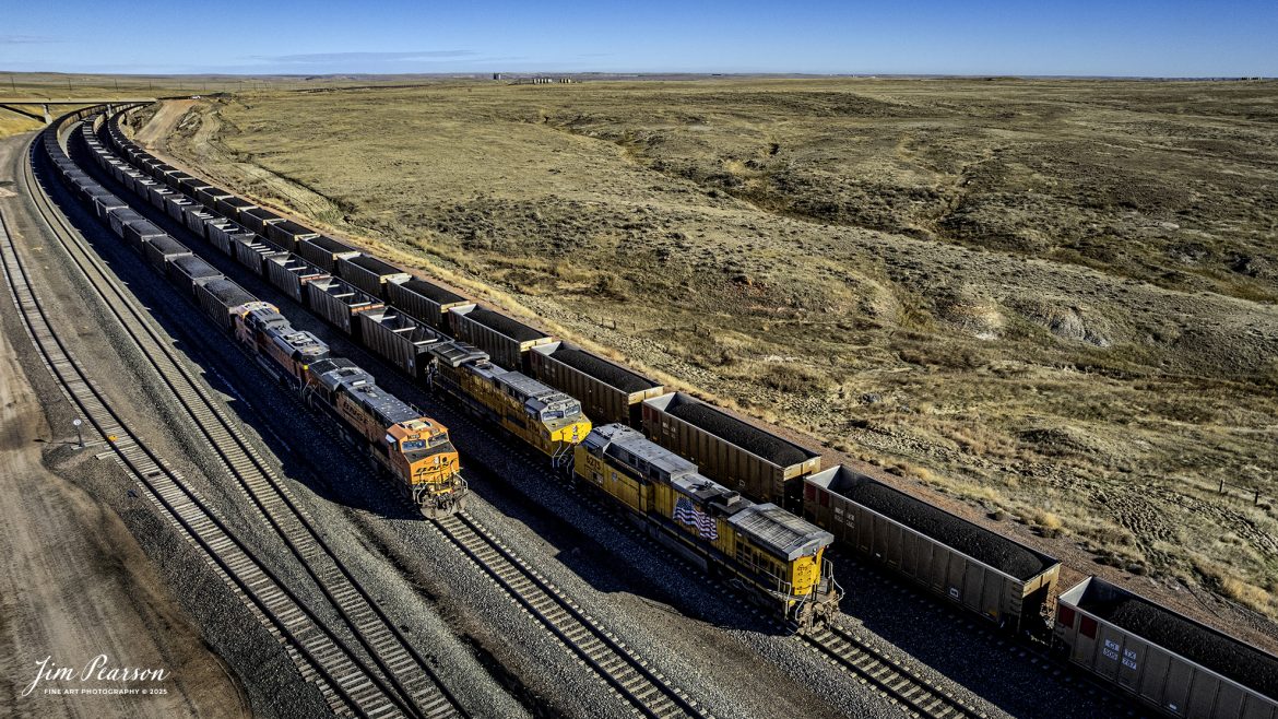 Two loaded outbound BNSF coal trains pass an inbound Union Pacific empty coal train in the Powder River Basin on Logan Hill at Nacco Junction, WY, on October 21st, 2025.

Nacco Junction lies on the "Joint Line", which is owned and operated by BNSF Railway and Union Pacific Railroad. This line was built by the Burlington Northern Railroad during 1979 and provides access to 11 large open pit coal mines in Wyoming's Powder River Basin. Together these mines produce nearly 400 million tons of coal a year, most of which feeds powerplants producing electricity. The line heading east leads to Peabody Energy's combined North Antelope and Rochelle Mines.

Tech Info: DJI Air 2S Drone, RAW, 22mm, f/2.8, 1/2000, ISO 140

#trains #railway #JimPearsonPhotography #trainsfromadrone #bnsf #up