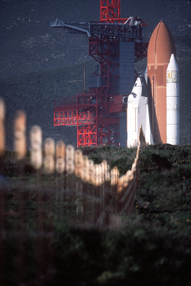 Blast From The Past - February 1, 1985 - The Space Shuttle Enterprise in launch position on the Space Launch Complex (SLC) #6, commonly known as "SLICK 6", during the ready-to-launch checks to verify launch procedures at Vandenburg AFB, California. -  Photo by TSgt. James R. Pearson

According to the NASA Website: NASA ferried Enterprise to Vandenberg Air Force Base in California to conduct fit checks at the Space Launch Complex-6 (SLC-6), which NASA had planned to use for polar orbiting shuttle missions. NASA used Enterprise to conduct tests at SLC-6 similar to the 1979 tests at KSC’s Launch Complex 39. The tests at Vandenberg complete, NASA ferried Enterprise back to Dryden on May 24, 1985.

From Wikipedia: Space Shuttle Enterprise (Orbiter Vehicle Designation: OV-101) was the first orbiter of the Space Shuttle system. Rolled out on September 17, 1976, it was built for NASA as part of the Space Shuttle program to perform atmospheric test flights after being launched from a modified Boeing 747. It was constructed without engines or a functional heat shield, and was therefore not capable of spaceflight.

Originally, Enterprise had been intended to be refitted for orbital flight to become the second space-rated orbiter in service. However, during the construction of Space Shuttle Columbia, details of the final design changed, making it simpler and less costly to build Challenger around a body frame that had been built as a test article. Similarly, Enterprise was considered for refit to replace Challenger after the latter was destroyed, but Endeavour was built from structural spares instead.

Enterprise was restored and placed on display in 2003 at the Smithsonian's new Steven F. Udvar-Hazy Center in Virginia. Following the retirement of the Space Shuttle fleet, Discovery replaced Enterprise at the Udvar-Hazy Center, and Enterprise was transferred to the Intrepid Sea, Air & Space Museum in New York City, where it has been on display since July 2012