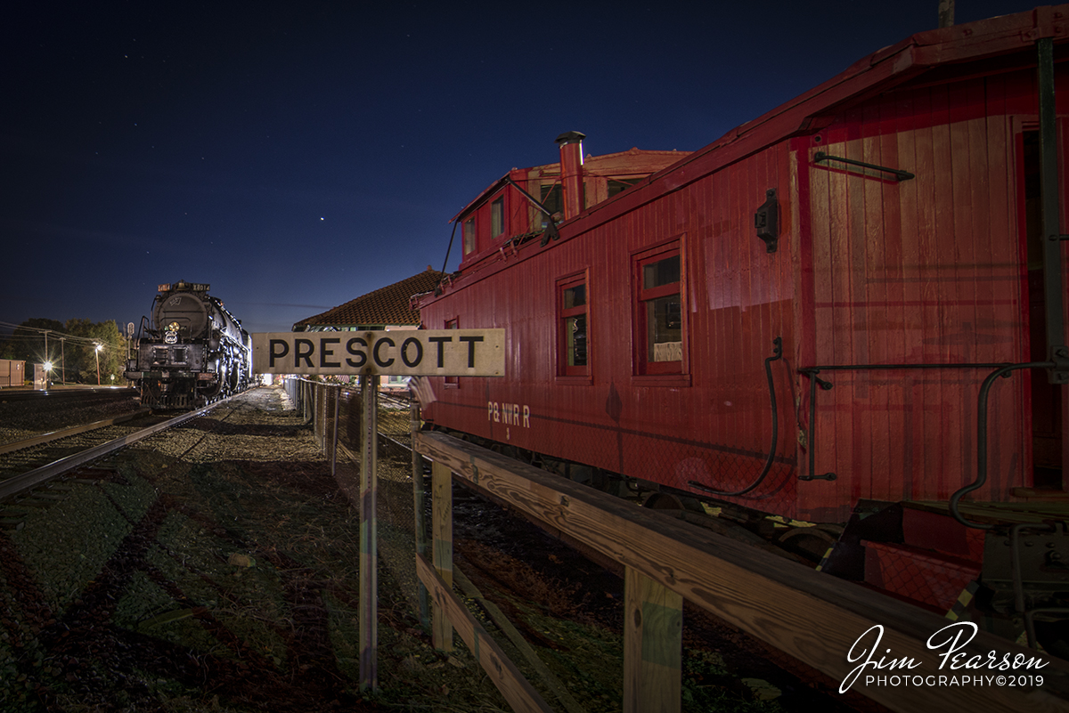 November 12, 2019 - Union Pacific Big Boy 4014 sits tied down at the Prescott, Arkansas depot, after its run for the day up the Little Rock Subdivision. Tomorrow morning it'll depart at 9am CST for Little Rock where it'll be on display till Friday morning before continuing it's move back to Cheyenne, Oklahoma. 

According to Wikipedia: The Missouri Pacific Depot of Prescott, Arkansas is located at 300 West 1st Street North. It is a 1-1/2 story red brick building, with a breezeway dividing it into two sections. One section continues to be reserved for railroad storage, while the other, the former passenger ticketing and waiting area, has been adapted for use by the local chamber of commerce and as a local history museum. It was built in 1911-12 by the Prescott and Northwestern Railroad, which interconnected with the Missouri-Pacific Railroad at Prescott. The line had passenger service until 1945.

The building is now known as the Nevada County Depot and Museum. Exhibits include area settlers, railroads, and military items from World War I, World War II, the American Legion, National Guard of the United States, 1941 U.S. Army maneuvers in Prescott.

The depot building was listed on the National Register of Historic Places in 1978.