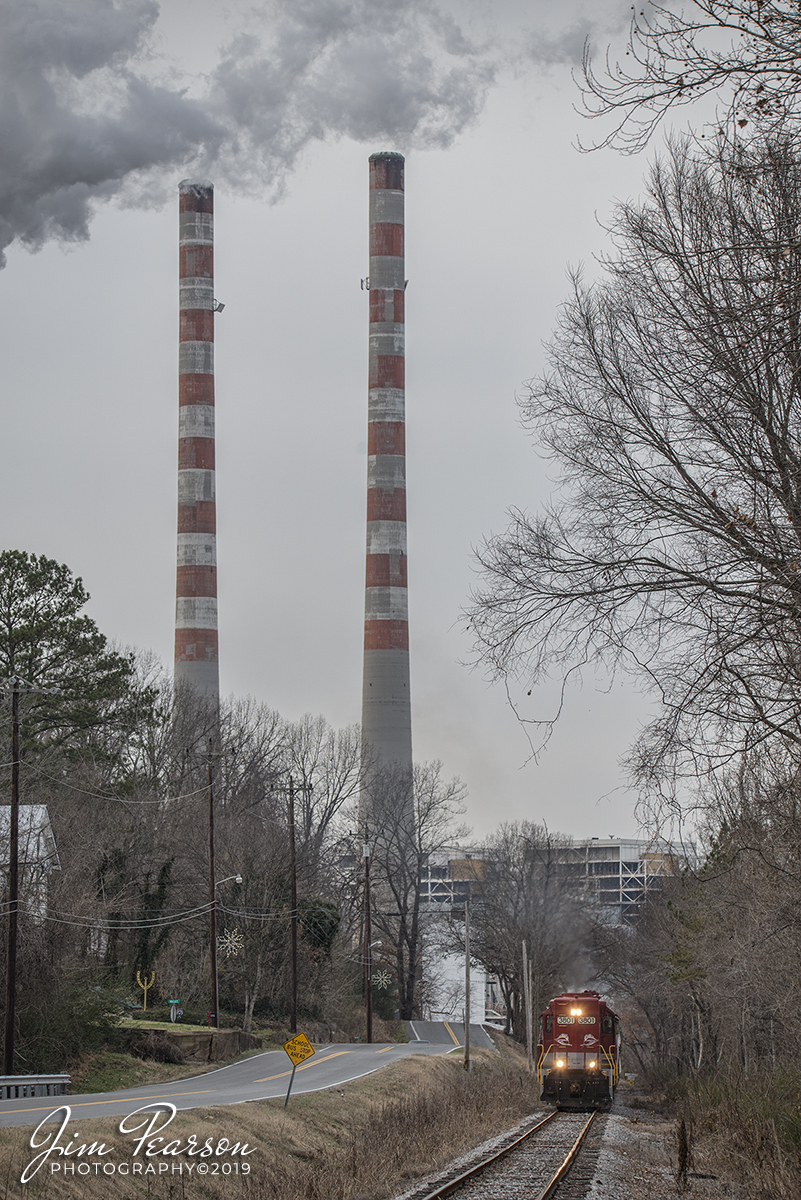 December 20, 2019 - RJ Corman's Cumberland City local passes the TVA Cumberland power plant (coal delivered by barge) as it departs Cumberland City, Tennessee on its way back north on the Memphis Line, with RJC 3837 and 3801 leading, after completing its work in Cumberland City for the day.