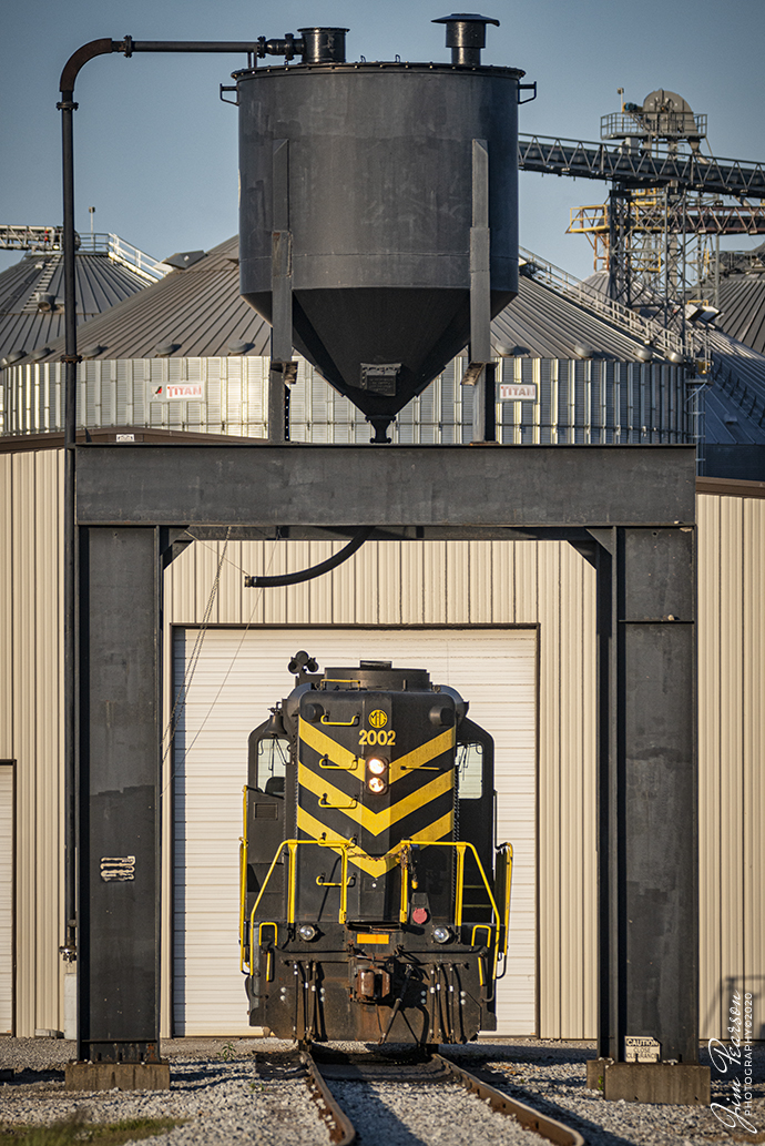 May 8, 2020 - The late afternoon sunlight rakes across sand tower area at MG Rail (MGRI) as locomotives 2002 sits at their engine house in Jeffersonville, Indiana. 

The shortline is owned and operated by Consolidated Grain and Barge (CG&B). It operates within the Clark Maritime Center, near Jeffersonville, Indiana. MGRI switches out several industries within the Maritime center and stages them at connections to CSX and Louisville & Indiana.

Tech Info: Nikon D800, RAW, Sigma 150-600 @340mm, f/7.6, 1/1600 sec at ISO 720.