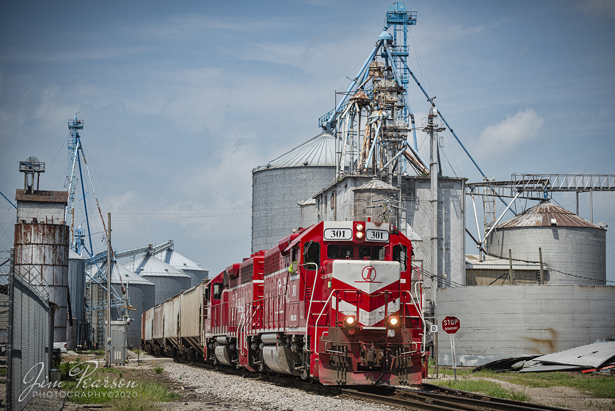 July 21, 2020  Indiana Railroad (INRD) 301 and 3001 power the Palestine Utility train 1 (PAUT-1), as it passes through granaries at Palestine, Illinois, on its way north back to INRDs Palestine Yard, after doing its work between the Marathon Refinery in Robinson, Illinois and Palestine on the INRD Indianapolis Subdivision.

According to Wikipedia: The Indiana Rail Road (reporting mark INRD) is a United States Class II railroad, originally operating over former Illinois Central Railroad trackage from Newton, Illinois, to Indianapolis, Indiana, a distance of 155 miles (249 km).

This line, now known as the Indiana Rail Roads Indianapolis Subdivision, comprises most of the former IC line from Indianapolis to Effingham, Illinois; Illinois Central successor Canadian National Railway retains the portion from Newton to Effingham. INRD also owns a former Milwaukee Road line from Terre Haute, Indiana, to Burns City, Indiana (site of the Crane Naval Surface Warfare Center), with trackage rights extending to Chicago, Illinois.

Tech Info: Full Frame Nikon D800, RAW, Nikkor 70-300 @ 80mm, f/4.5, 1/1250, ISO 125.