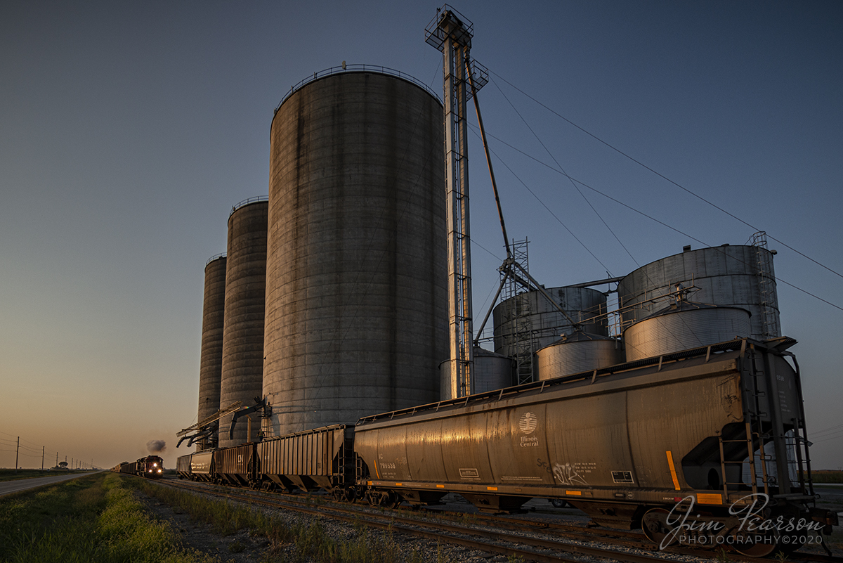August 29, 2020 - A puff of smoke in the early morning light leaps from the engine on CN L533-91 as a fresh crew on Illinois Central (in CN Paint) 9634 and 8879 prepare to depart Total Grain Marketing in Newton, Illinois, as the warm glow of the early morning sunrise illuminates the scene. 

A fresh crew had just boarded the train and were taking the train on to Effingham, IL on CN's Effingham Subdivision.

Tech Info: Full Frame Nikon D800, RAW, Irex 11mm, f/5, 1/500, ISO 125.