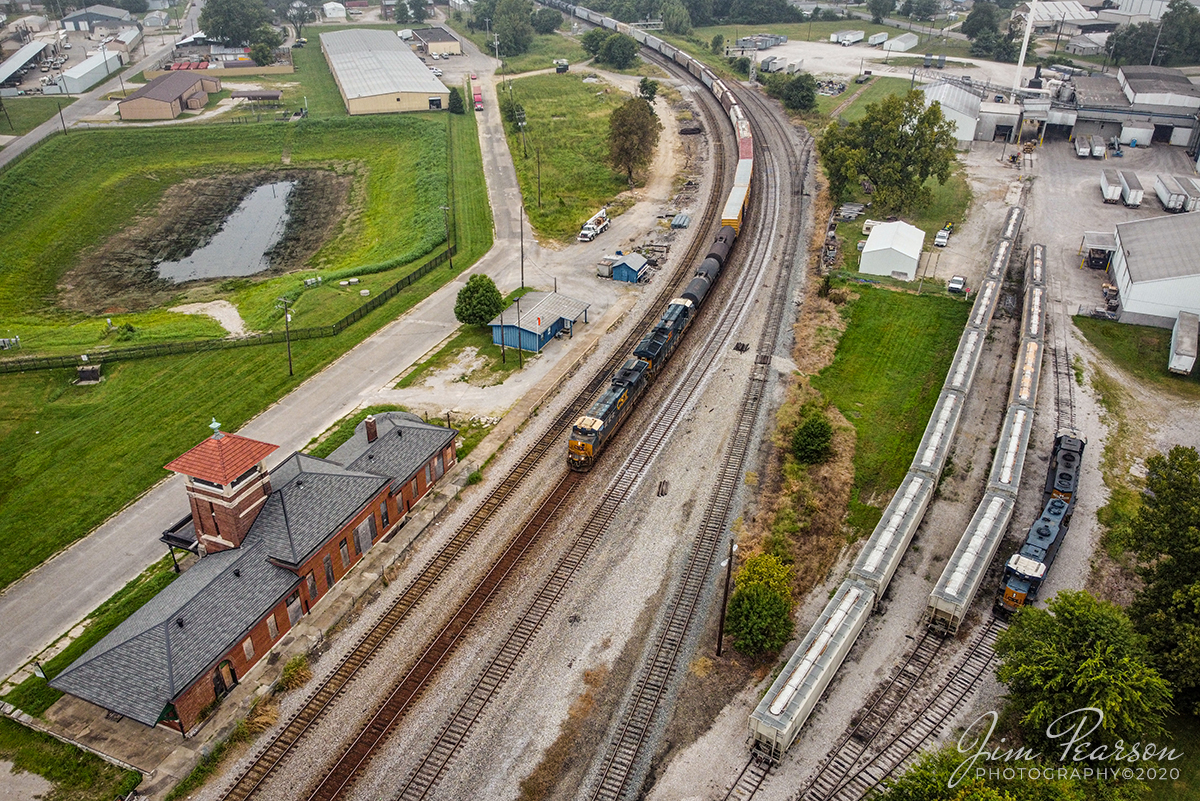 September 12, 2020 - CSX K811 heads south on the Henderson Subdivision as it passes the old Louisville & Nashville Depot at Henderson, Kentucky.

From various sources on the web: The first L&N depot in Henderson, at Fourth and Adams streets, was constructed in 1875. The two-story, wood-framed passenger depot for the L&N cost $2,000 to erect and contained five offices and two waiting rooms. The Ohio Valley Railroad was built in 1892 between Hopkinsville and Gracey, who had built a depot at Ninth Street. The Ohio Valley was acquired by the IC in 1897.

A replacement depot, built of brick and granite, was constructed by the local firm Bailey & Koerner opened at the cost of $25,000 on July 1, 1902. The Union Station replaced the separate stations for the L&N and the IC. The former L&N depot was converted into the residence for the local yard foreman while the former IC station was used until it was demolished in November 1942.

By 1922, Union Station was handling 24 passenger trains daily, but the advent of the automobile and the construction of the interstate highway system and parkways in the region decimated passenger trains. The IC ceased passenger operations on February 13, 1941, and the station was closed by the L&N after it ceased passenger trains in 1971.

In 2015, the city requested bids to either demolish or restore Union Station. 7 Two companies placed bids to tear down the building while Architectural Renovators of Evansville, Indiana submitted the only bid to restore the depot. The city awarded the contract to Architectural Renovators in December and agreed to pay $80,000 towards restoring the building: Additionally, the city deeded the building over to Architectural Renovators, who were required to begin construction within six months and to complete exterior restoration within 36 months or be forced to give up the deed to the building.

Work to restore the building began almost immediately although the restoration company found the inside in worse condition than expected. A new roof was installed by the conclusion of 2016, with all exterior work mostly finished by February 2017. There's been no visible work on the depot since then.

Tech Info: DJI Mavic Mini Drone, JPG, 4.5mm (24mm equivalent lens) f/2.8, 1/320, ISO 100.